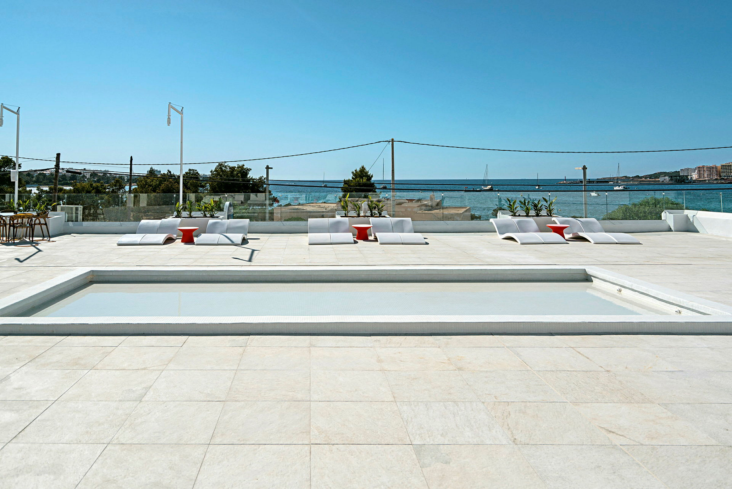 Solterrasse med pool, liggestole og udsigt over havet. (AI-genereret tekst)