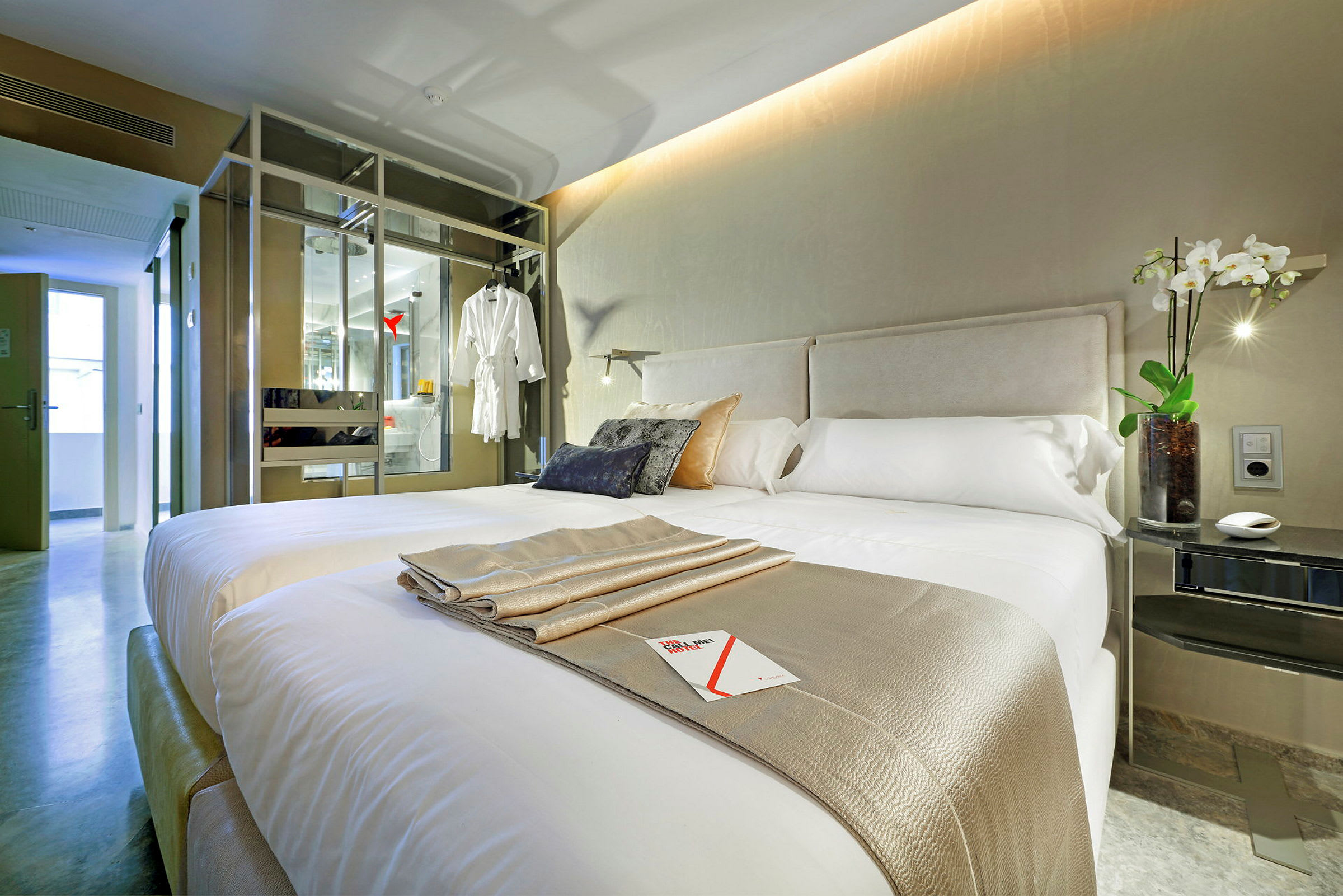 Billede af et moderne hotelværelse med en dobbeltseng, dekorative puder og en elegant indretning. (AI-genereret tekst)