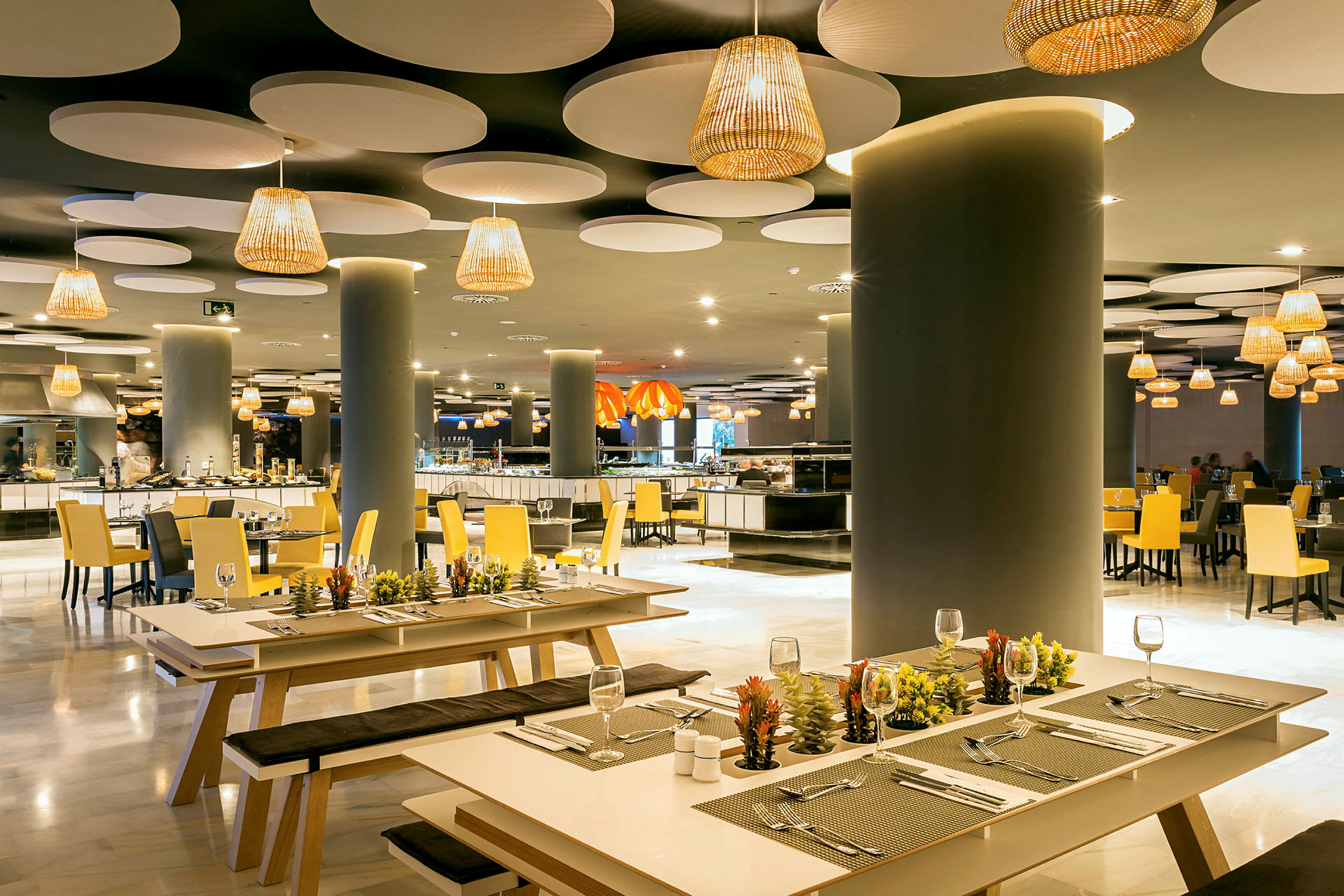 Elegant restaurant med moderne indretning, med bænke og borde dekoreret med små planter. (AI-genereret tekst)