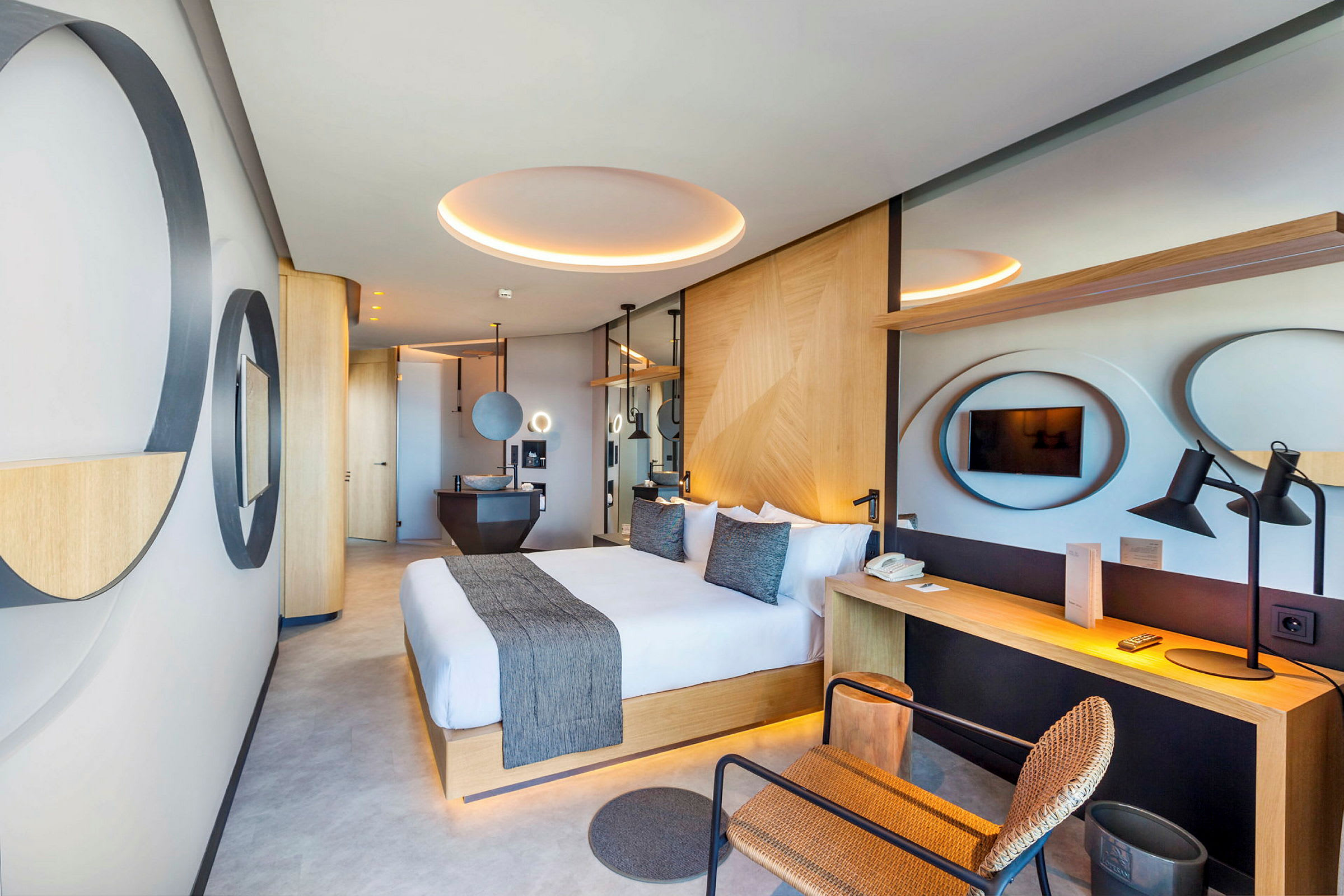 Moderne hotelværelse med stor dobbeltseng, skrivebord og TV. (AI-genereret tekst)