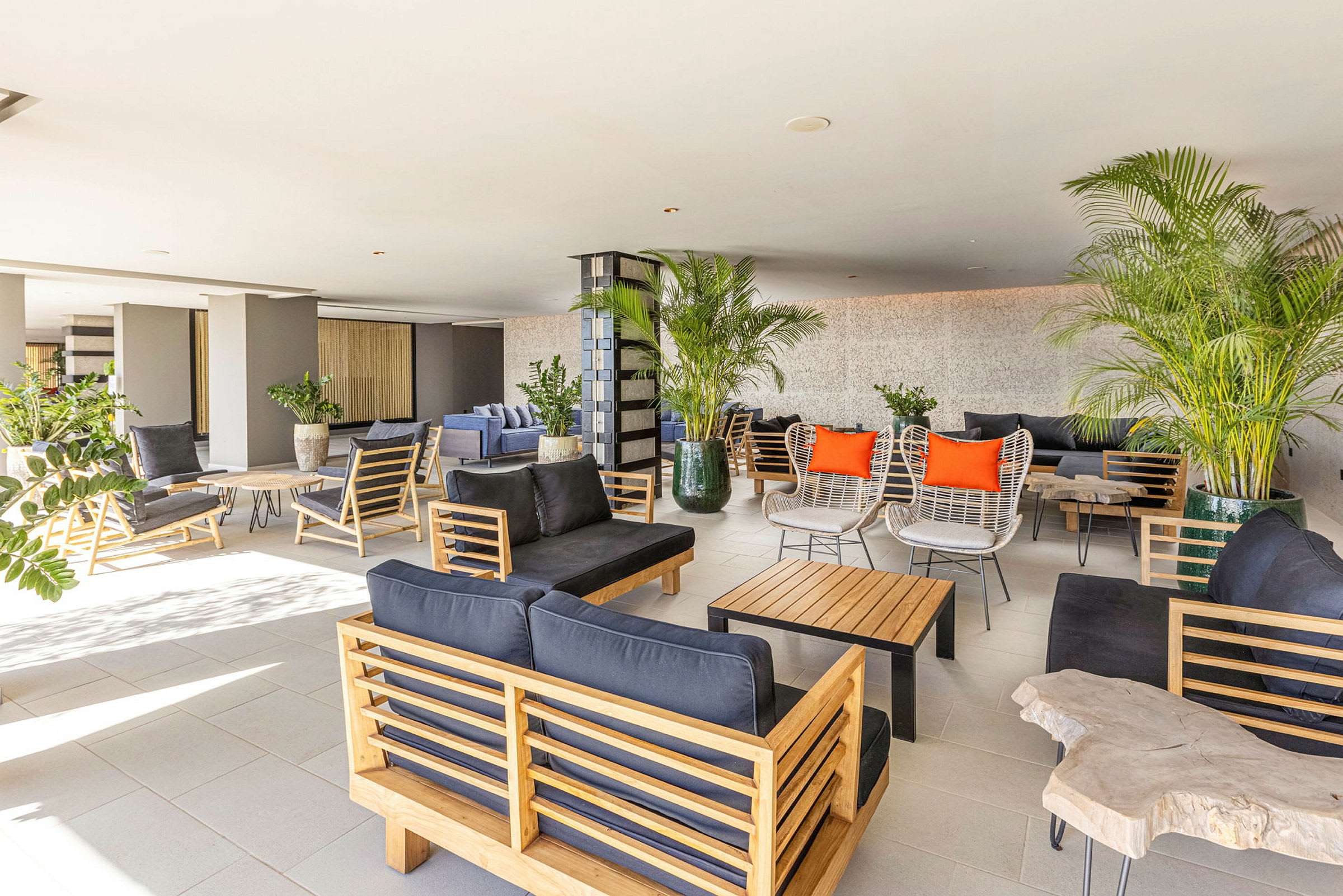 En rummelig og lys lounge med moderne møbler og grønne planter. (AI-genereret tekst)
