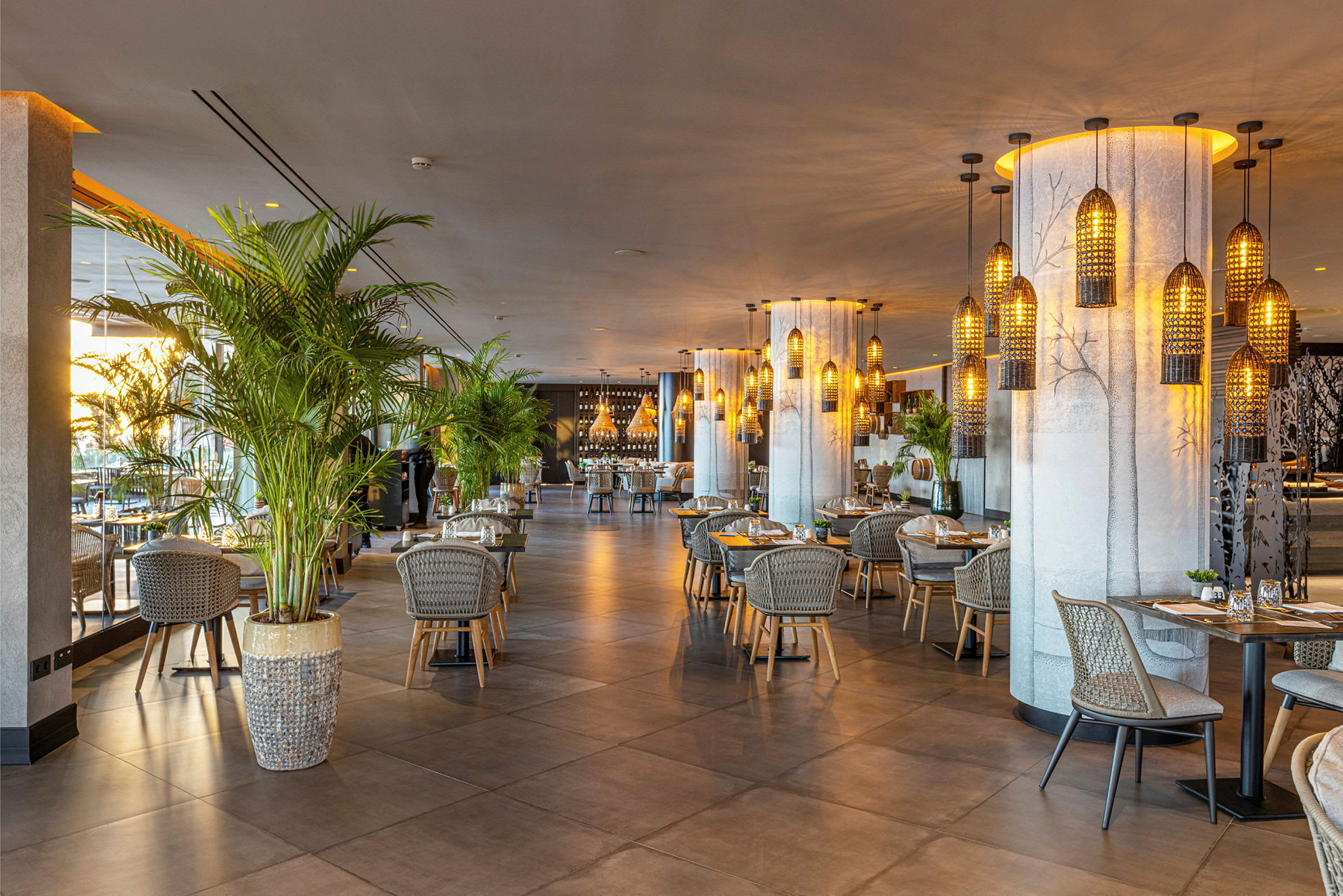 En moderne restaurant med borde og stole, omgivet af dekorationer og planter. (AI-genereret tekst)