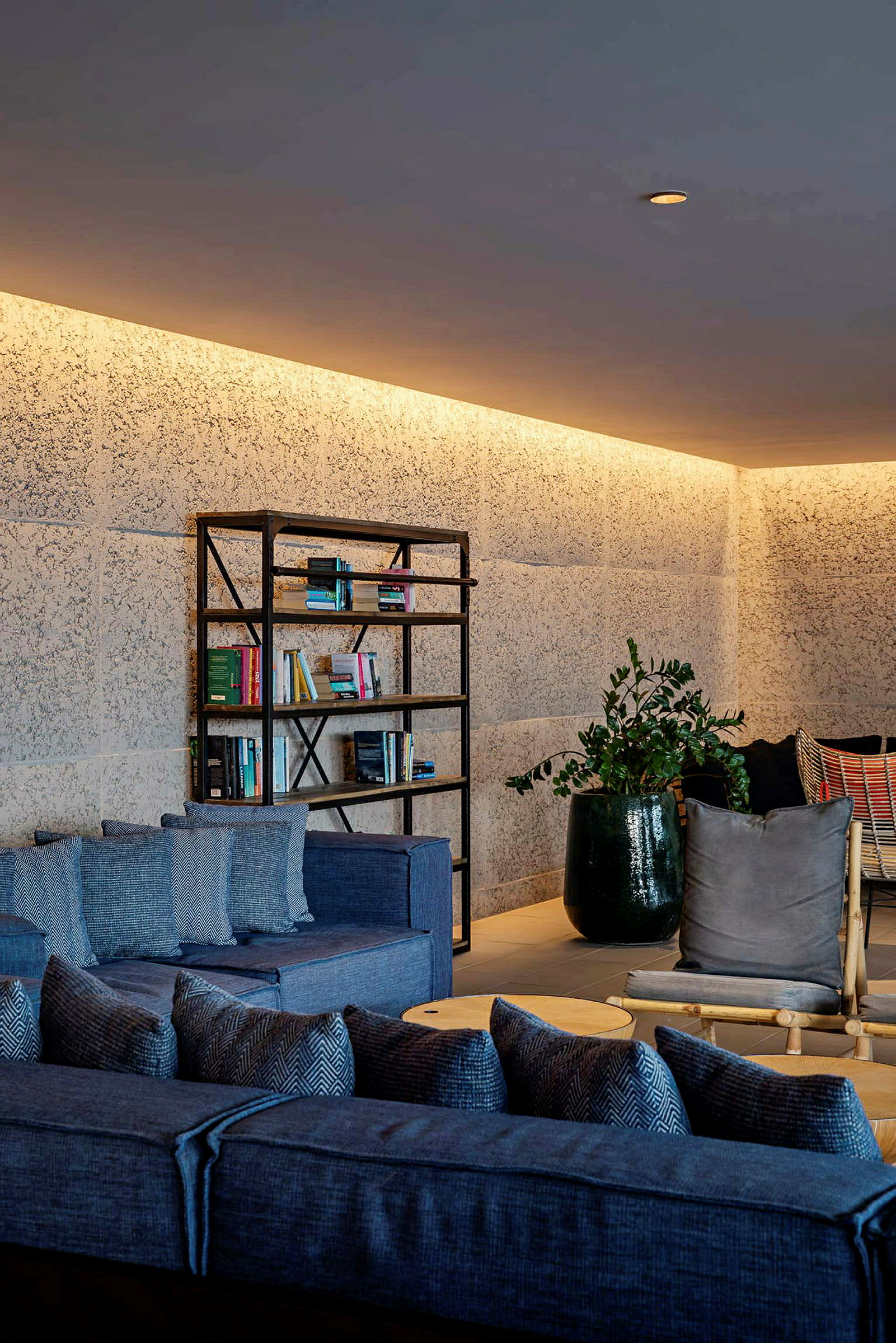 Møbleret lounge med reol, sofaer og planter. (AI-genereret tekst)