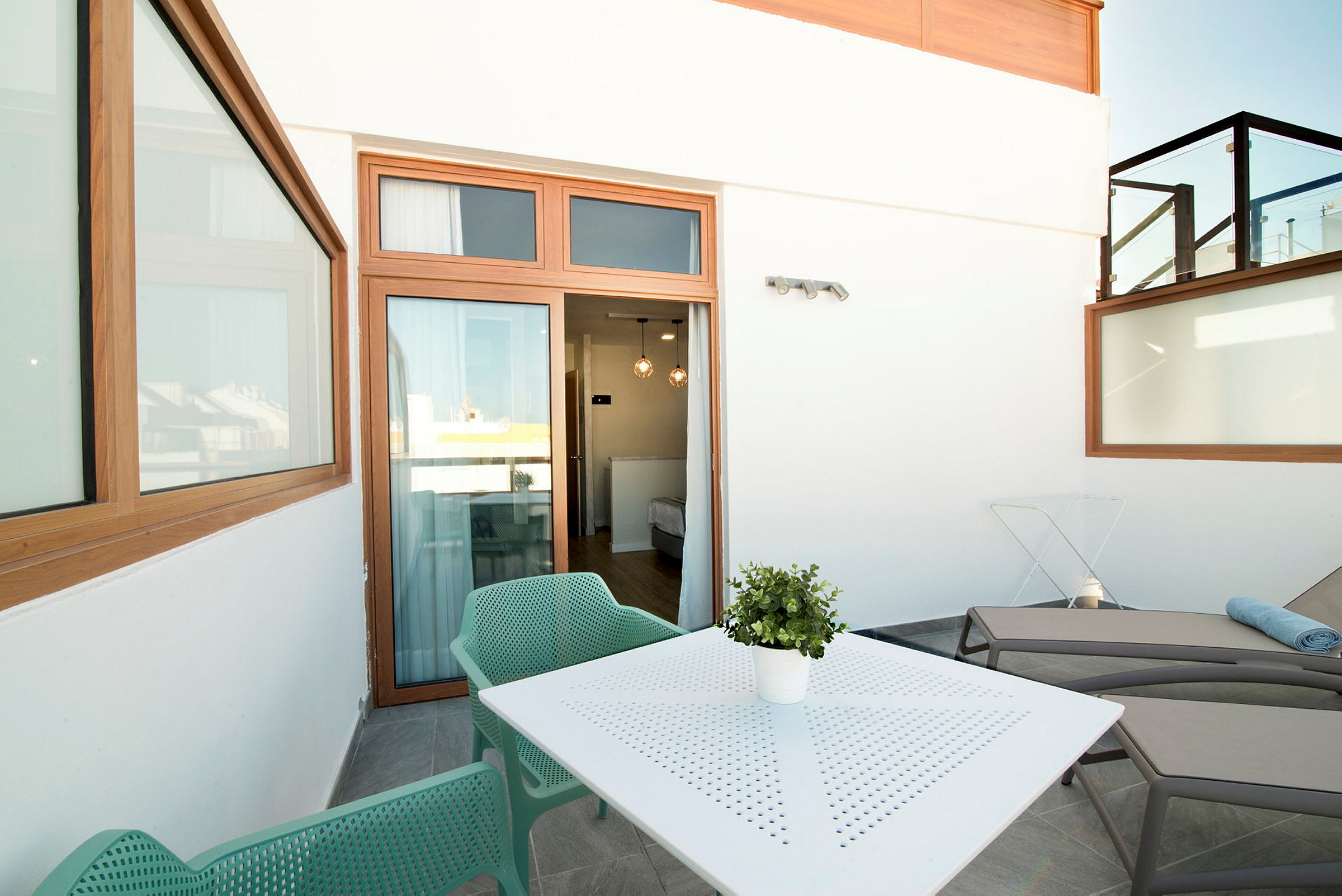 Møbleret terrasse med siddepladser, bord og solsenge. (AI-genereret tekst)