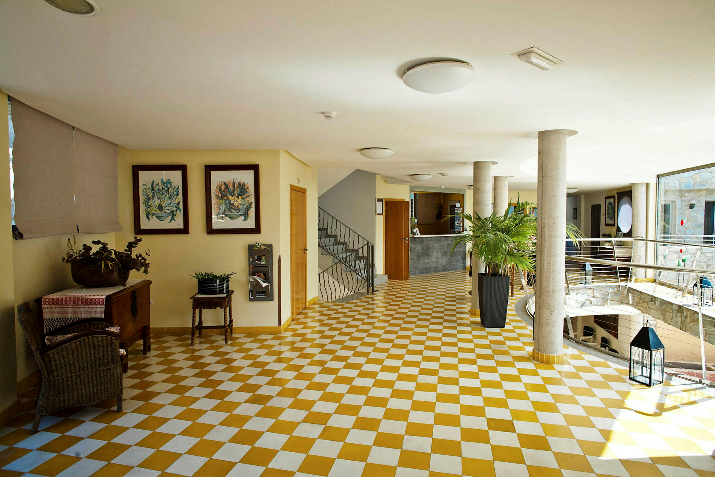 Lobbyområde med ternet gulv, møbler og planter. (AI-genereret tekst)