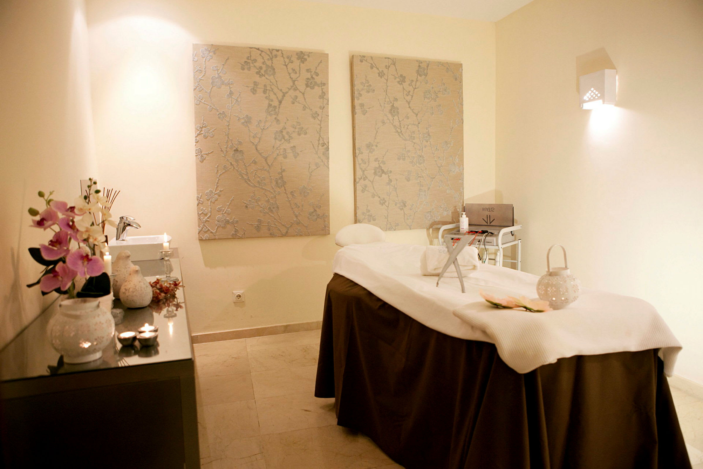 Et indbydende massage- og spa-behandlingsrum med oplyst interiør og dekorative elementer. (AI-genereret tekst)