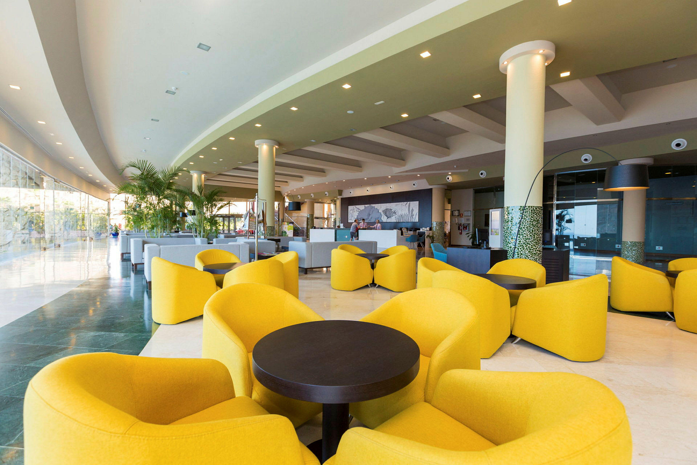 Interiør af en moderne hotellobby med gule loungestole og sofaer. (AI-genereret tekst)