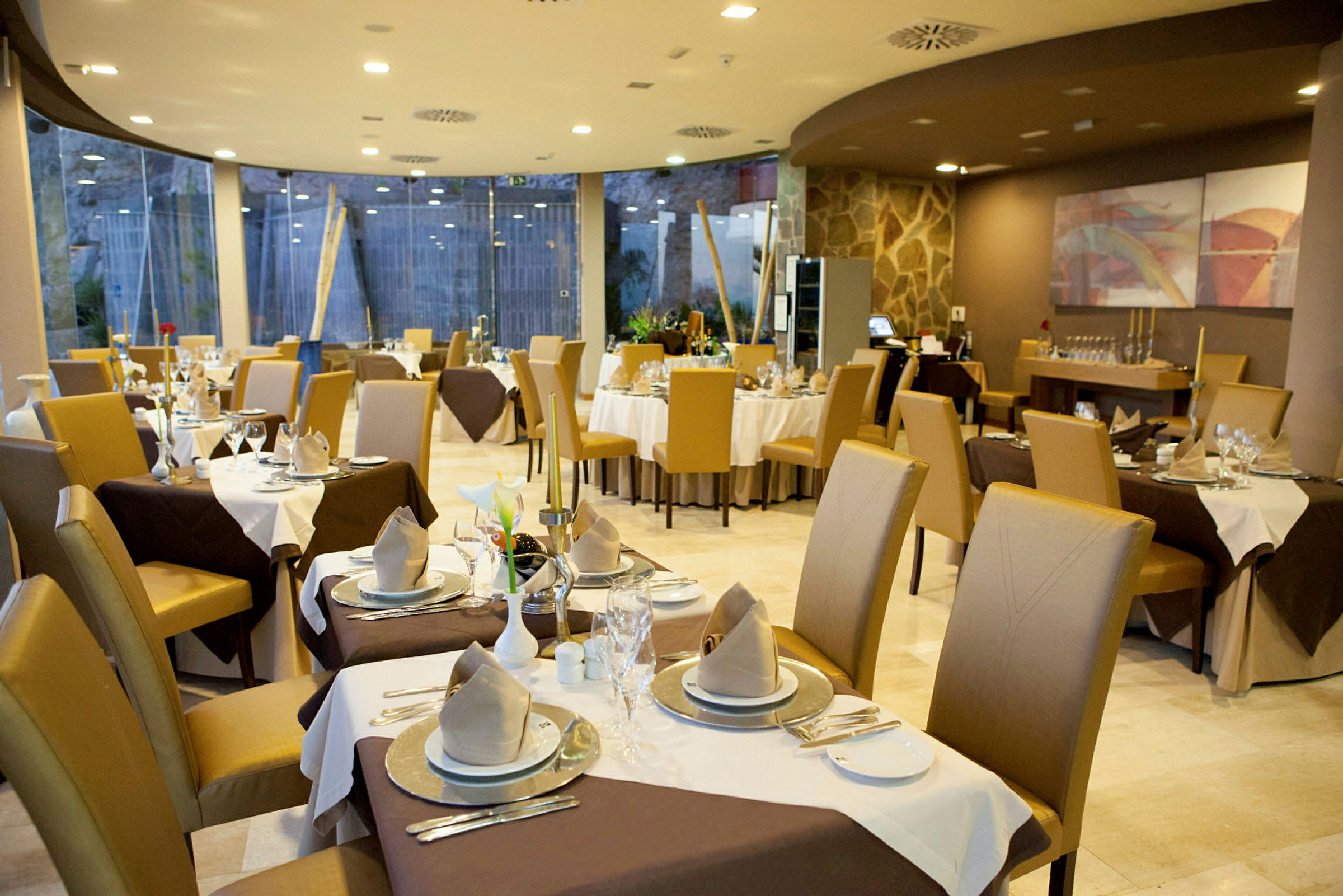 En elegant restaurant med dækkede borde og komfortable stole. (AI-genereret tekst)