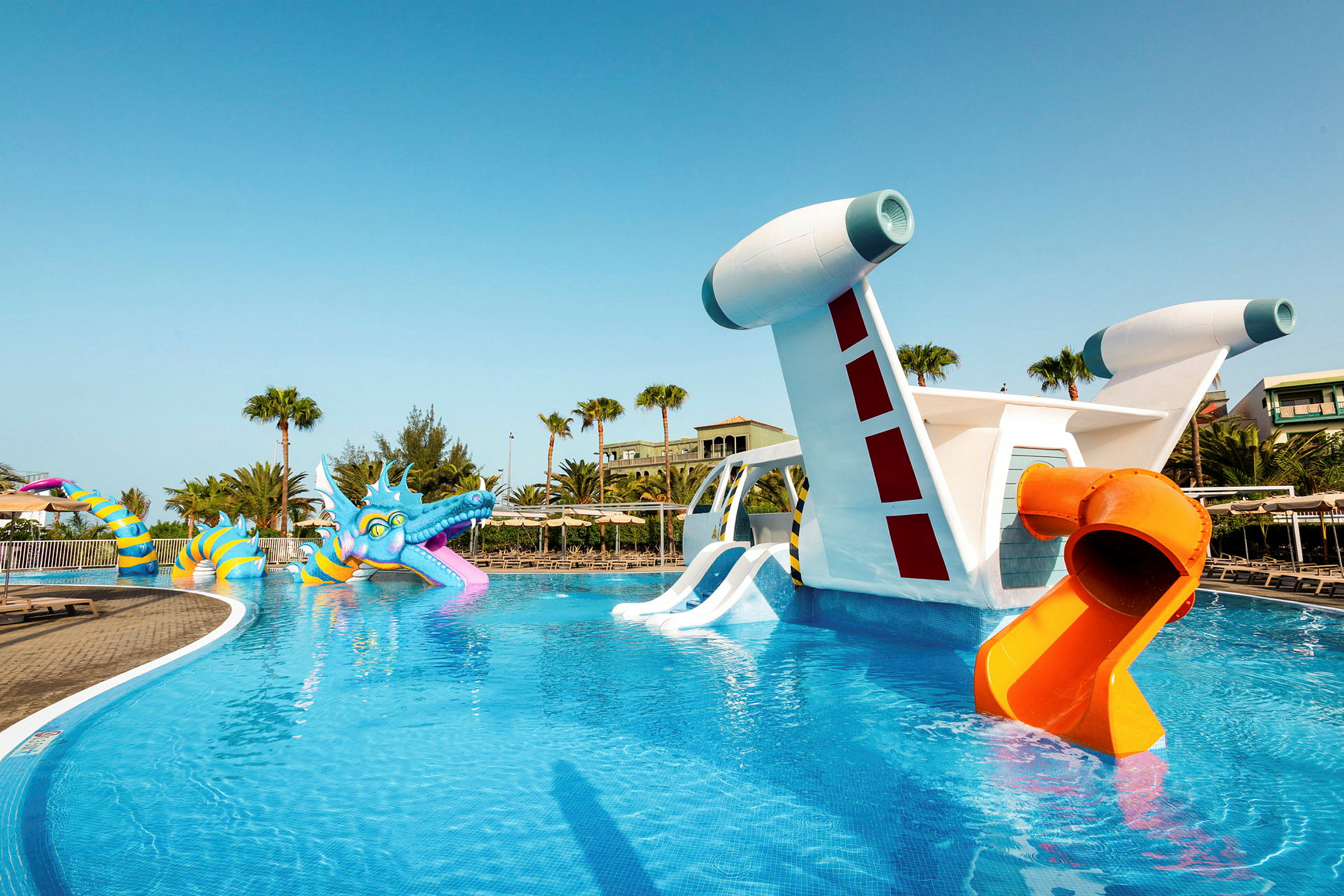 Pool med farverig vandrutsjebane og legeattraktioner. (AI-genereret tekst)