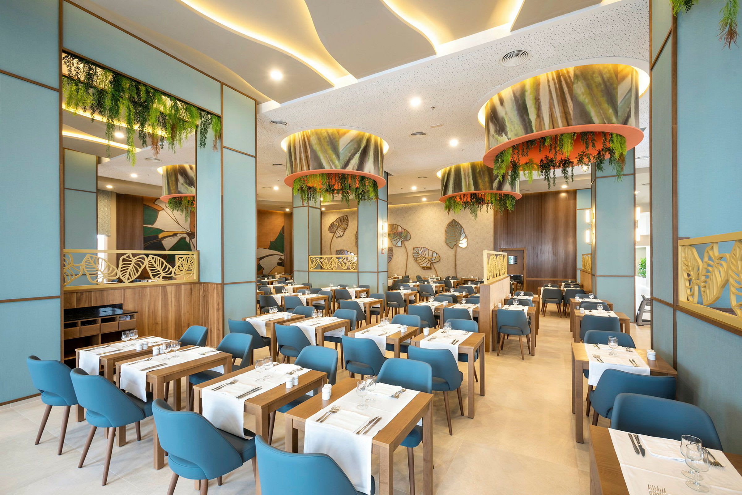 En moderne restaurantinteriør med træborde, blå stole og grønne dekorationer. (AI-genereret tekst)