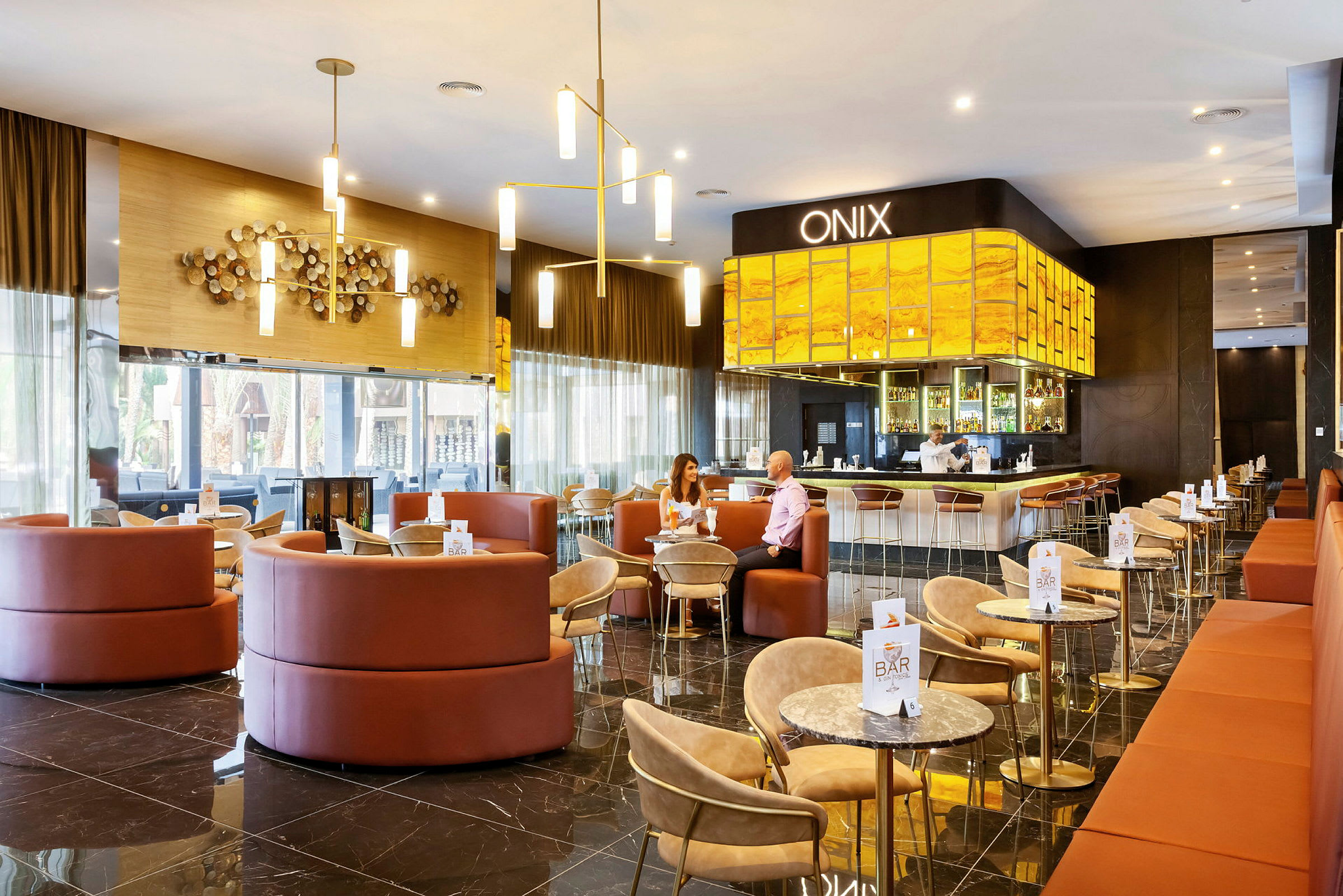 En elegant hotelbar med siddepladser og et oplyst serveringsområde. (AI-genereret tekst)