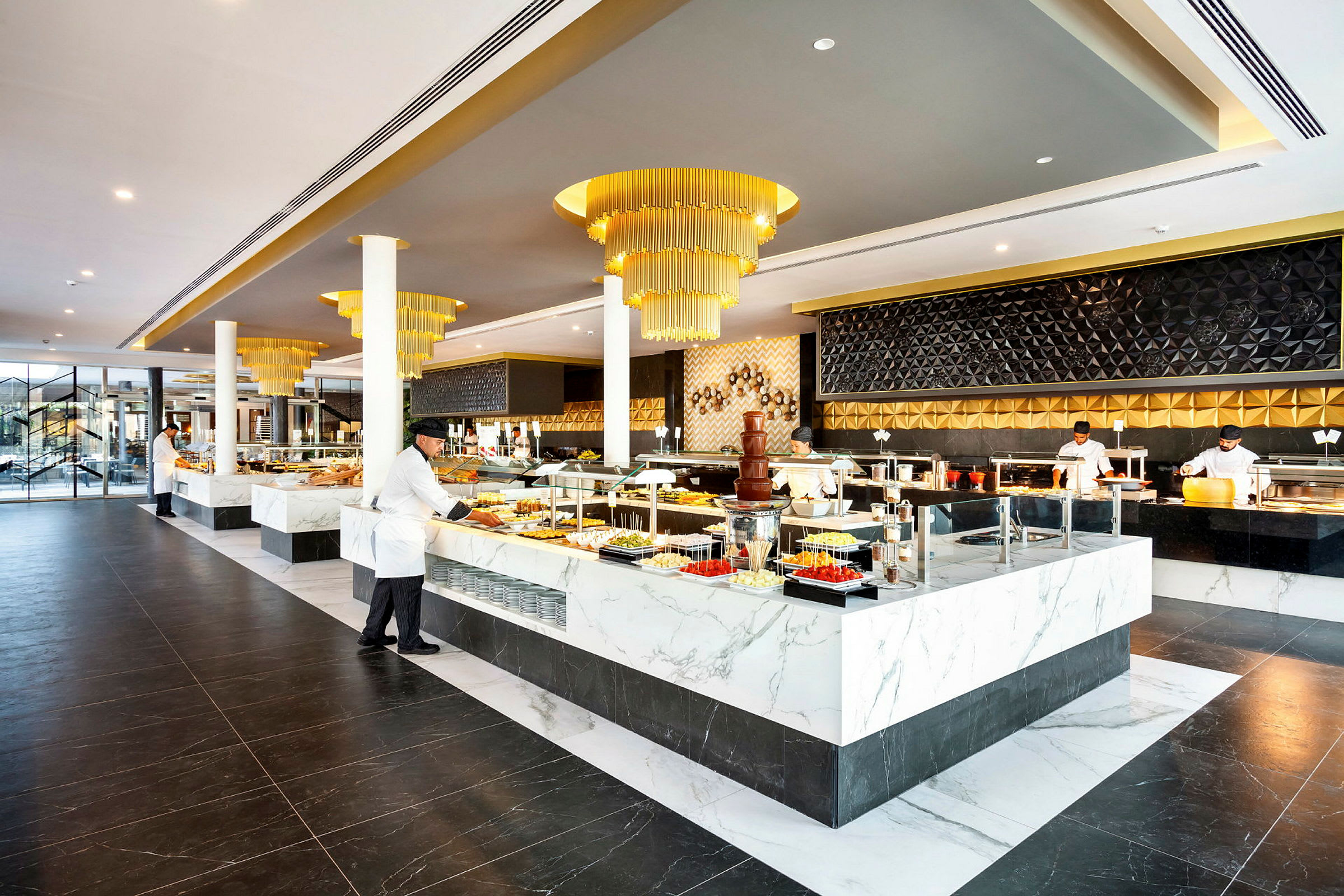 En elegant restaurantbuffet med moderne indretning og marmorbeklædte stationer fyldt med forskellige madtilbud. (AI-genereret tekst)