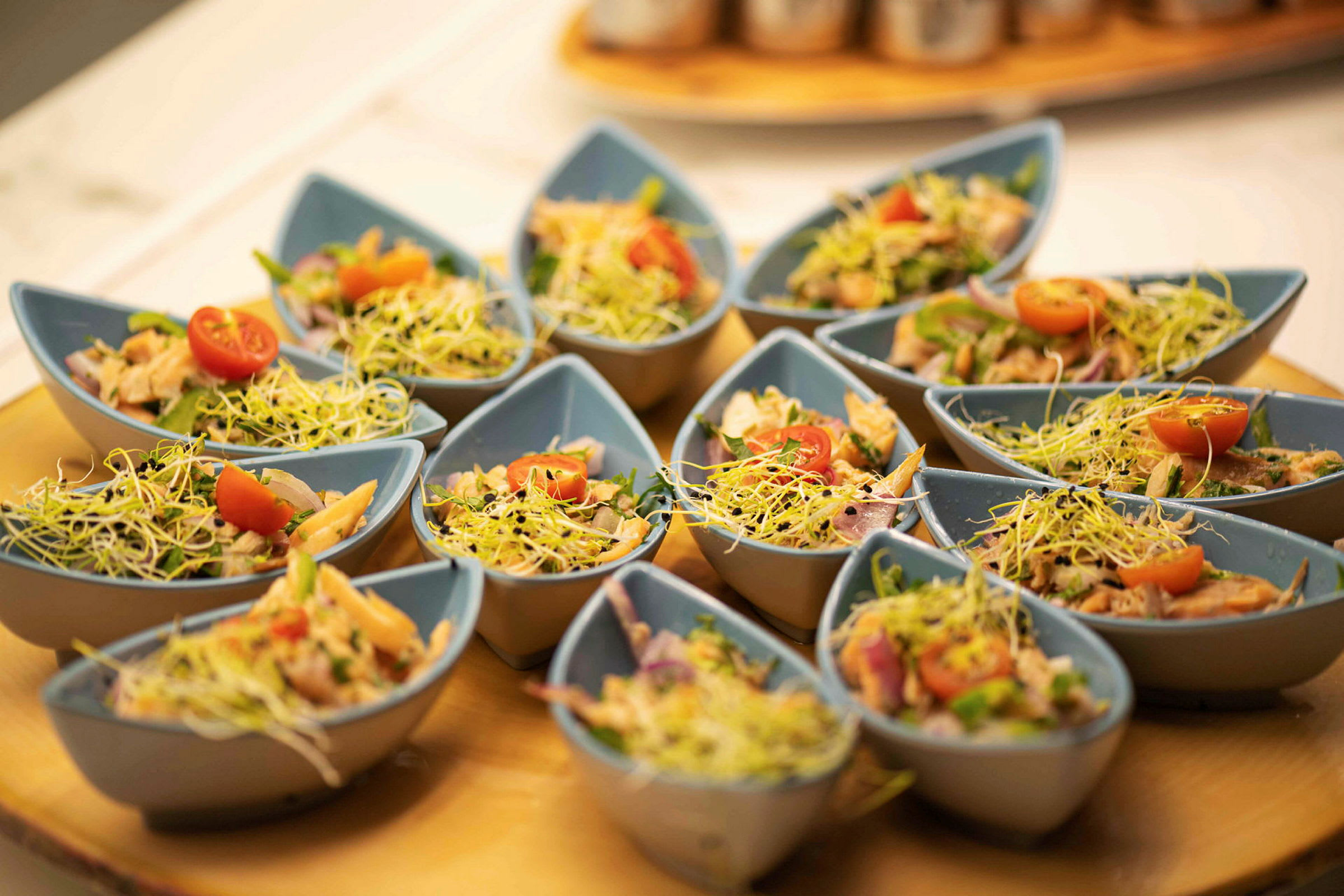Små portioner af salat i blå skåle med grøntsager og spirer. (AI-genereret tekst)