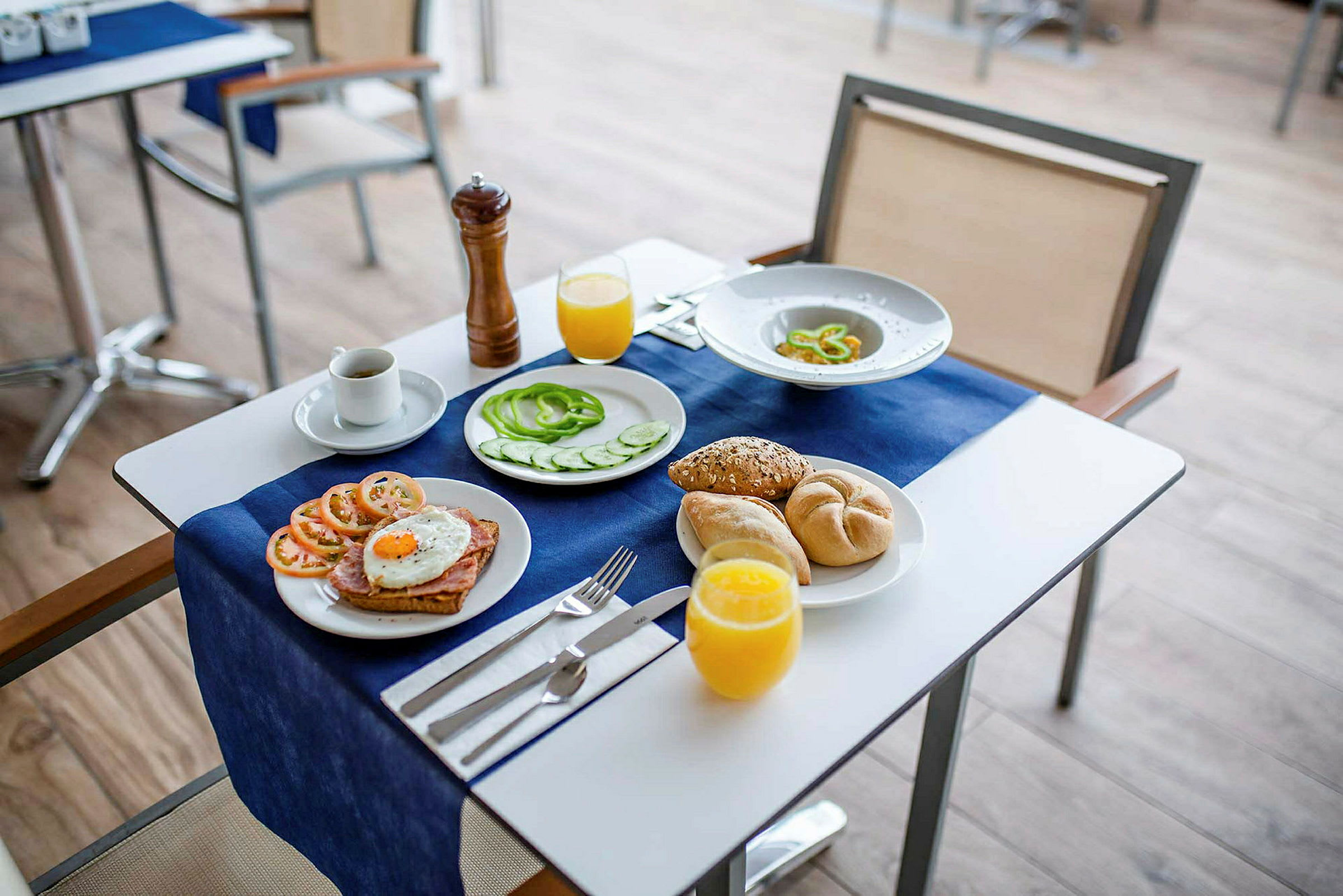 Morgenmad serveret med forskellige fødevarer, herunder æg, grøntsager, brød og drikke. (AI-genereret tekst)
