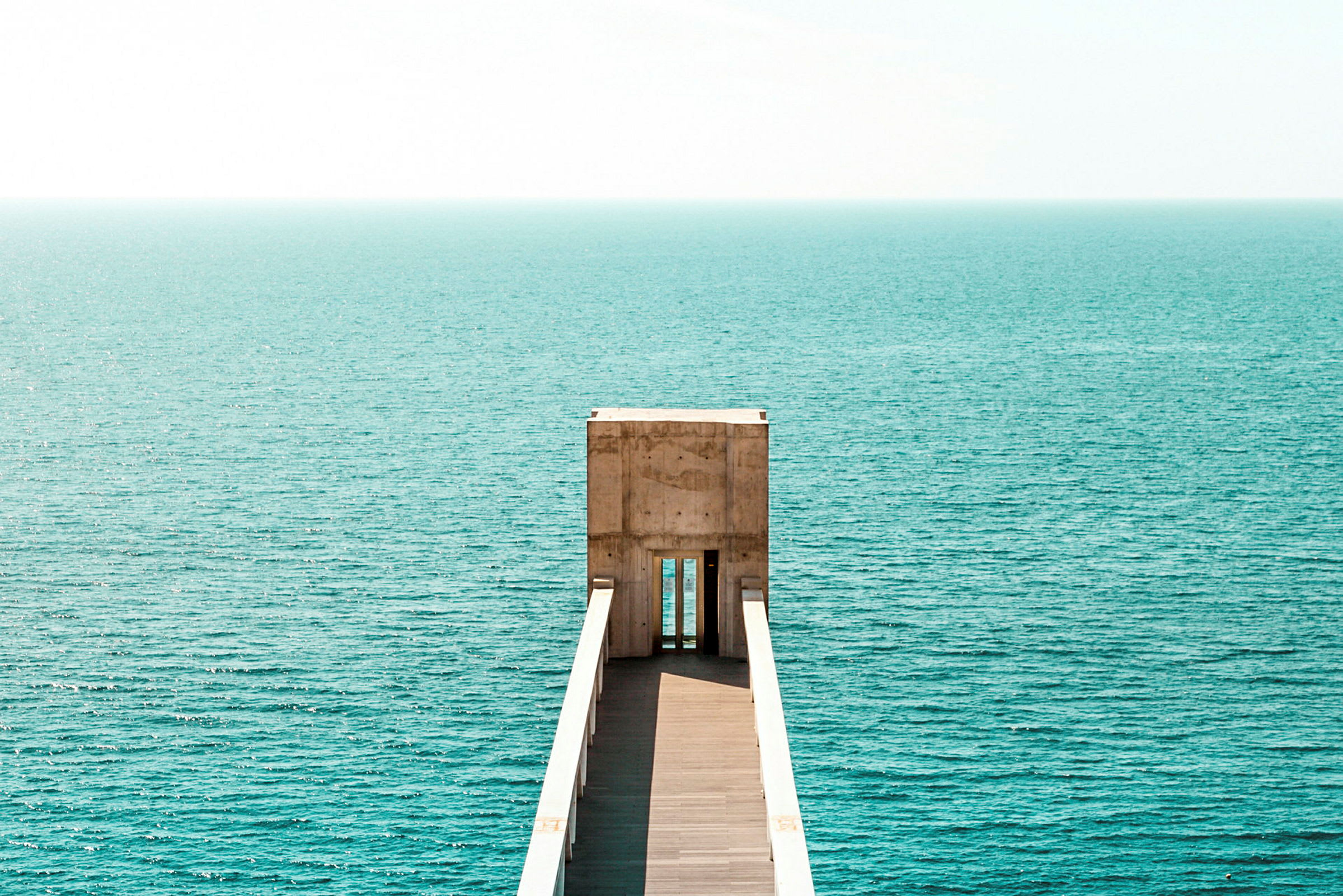 En mole, der fører ud mod havet under en klar himmel. (AI-genereret tekst)