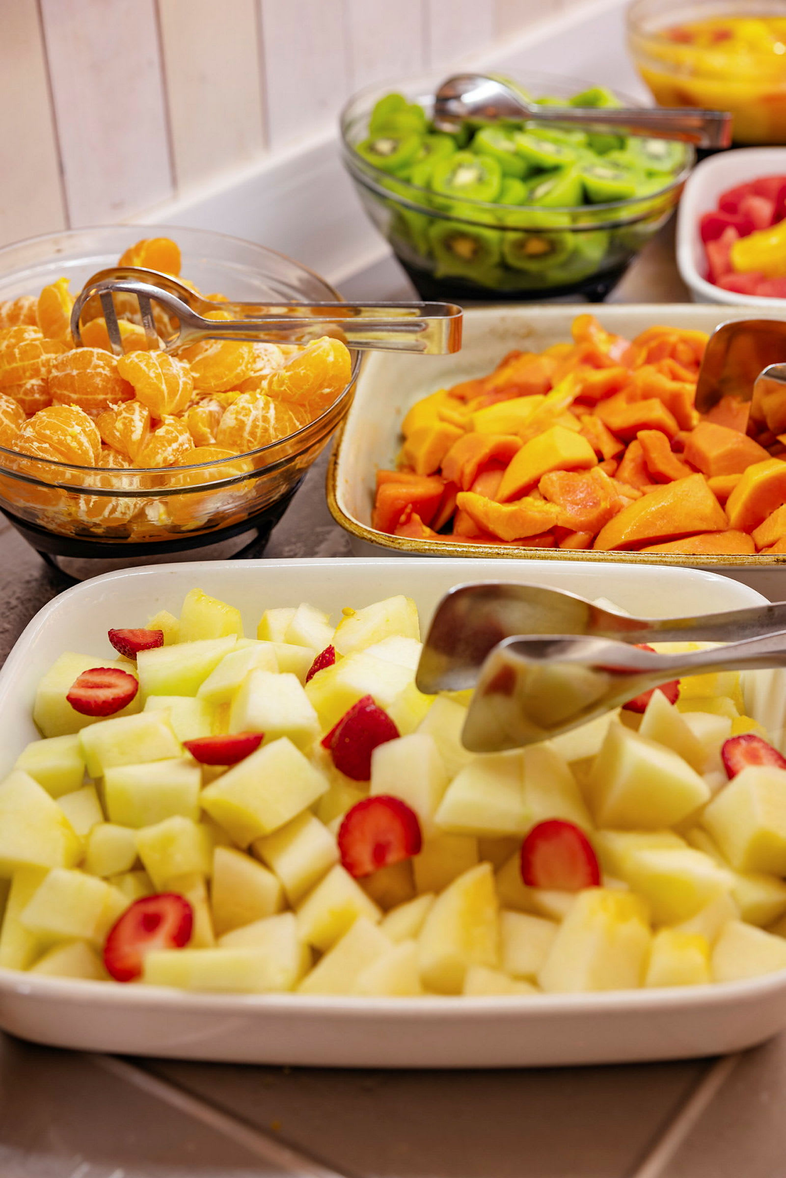 Frugt buffet med melon, jordbær, kiwi og citrusfrugter. (AI-genereret tekst)