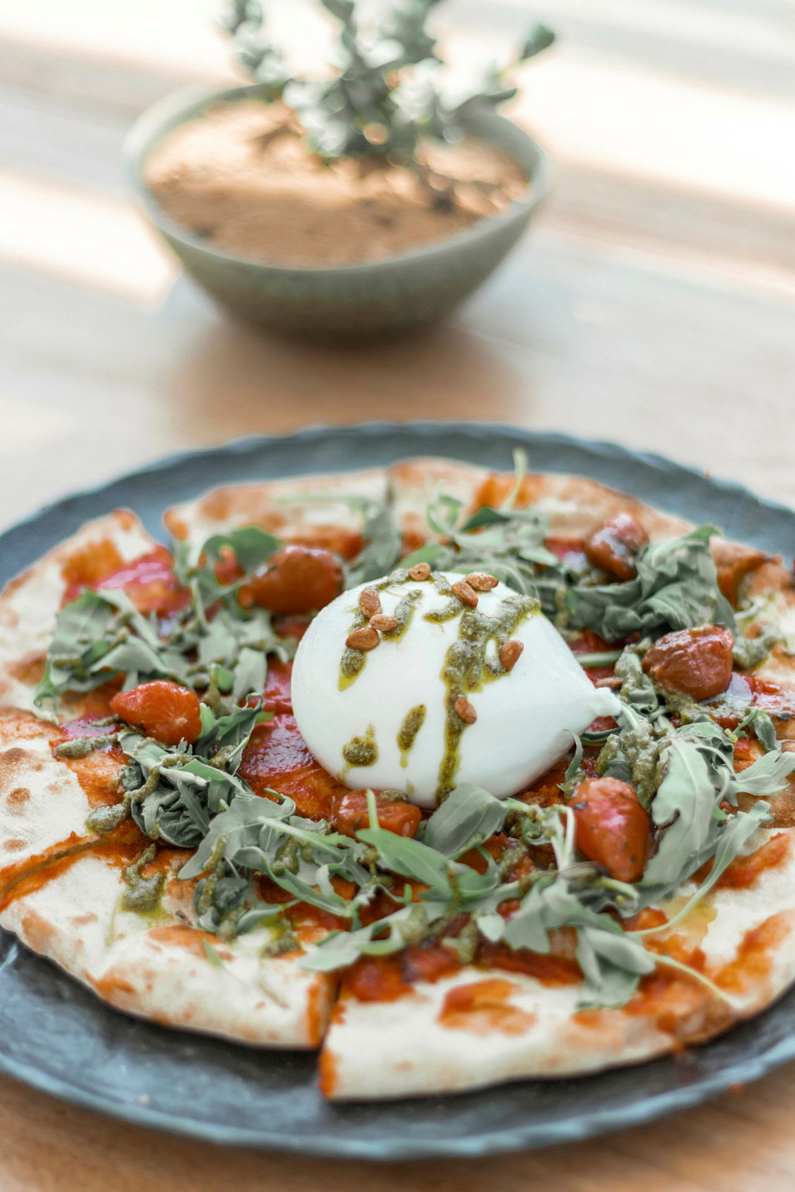 En ret med burrata og grøntsager på en bund. (AI-genereret tekst)