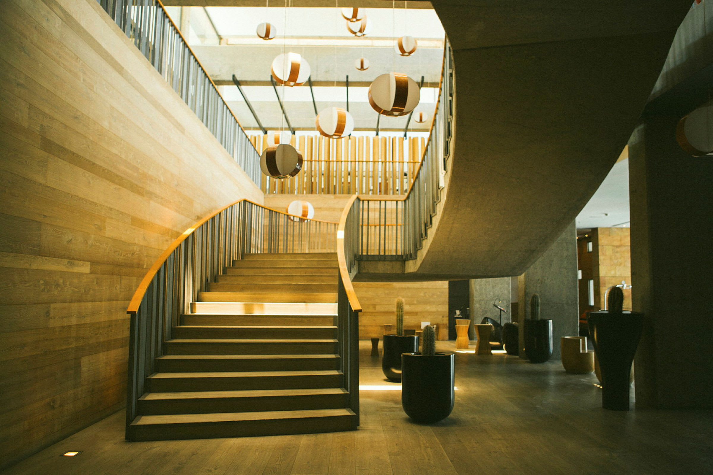 En trappe med buet design og træfarvede detaljer i et moderne miljø. (AI-genereret tekst)