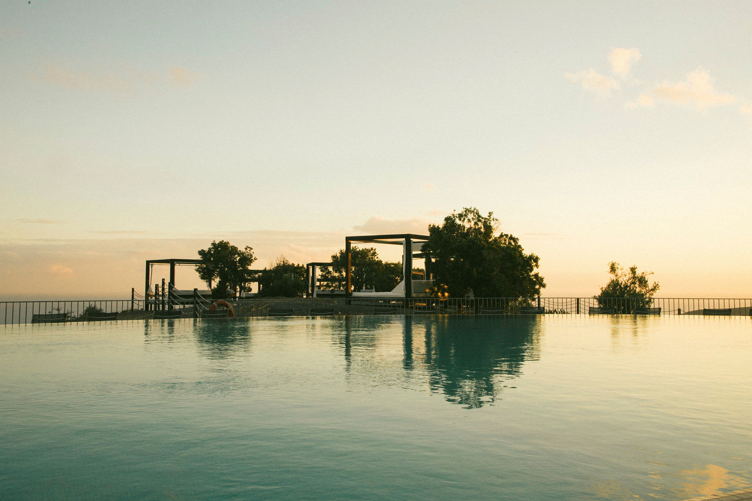 Udsigt over en infinitypool med himlen som reflekterende baggrund. (AI-genereret tekst)
