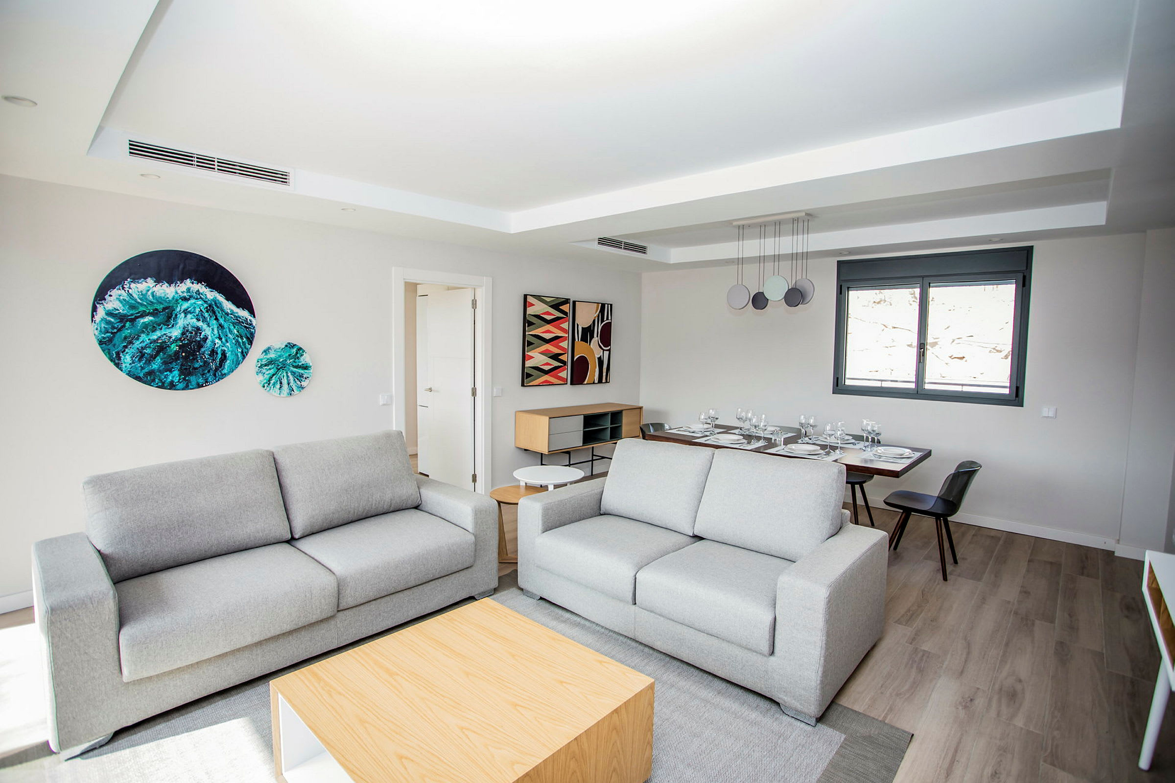 Et moderne indrettet siddeområde med to sofaer og et spisebord i baggrunden. (AI-genereret tekst)