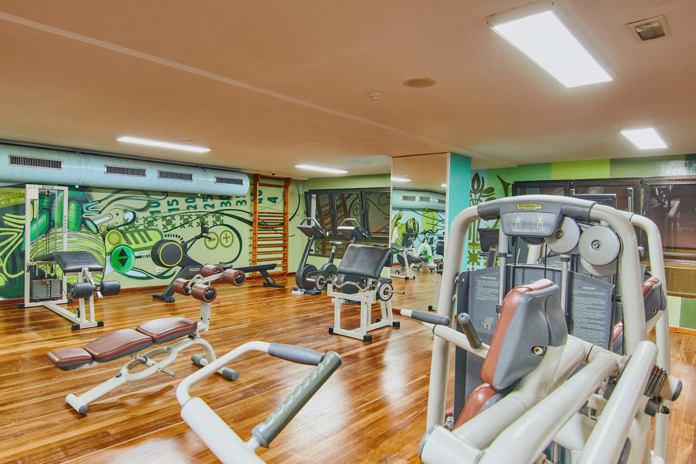 Et fitnesscenter med forskellige træningsmaskiner og udstyr. (AI-genereret tekst)