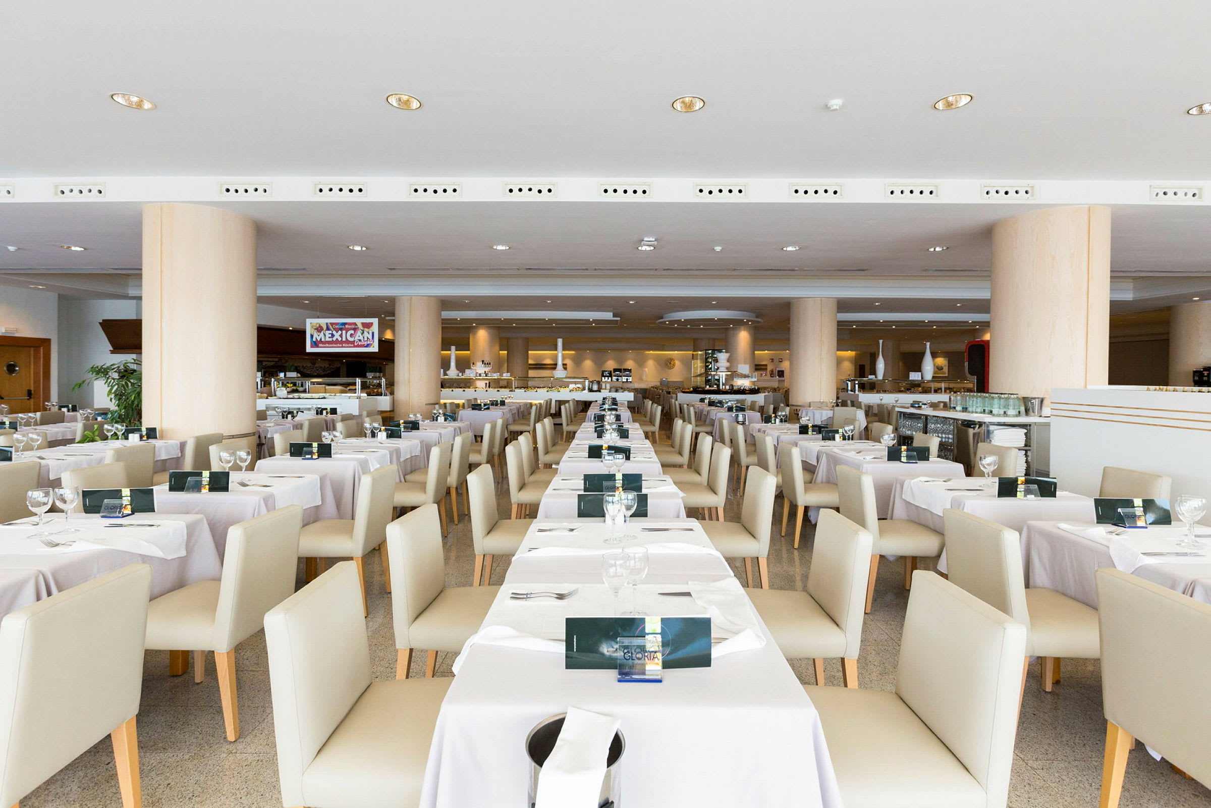 Interiør af en restaurant med dækkede borde og stole arrangeret i rækker. (AI-genereret tekst)