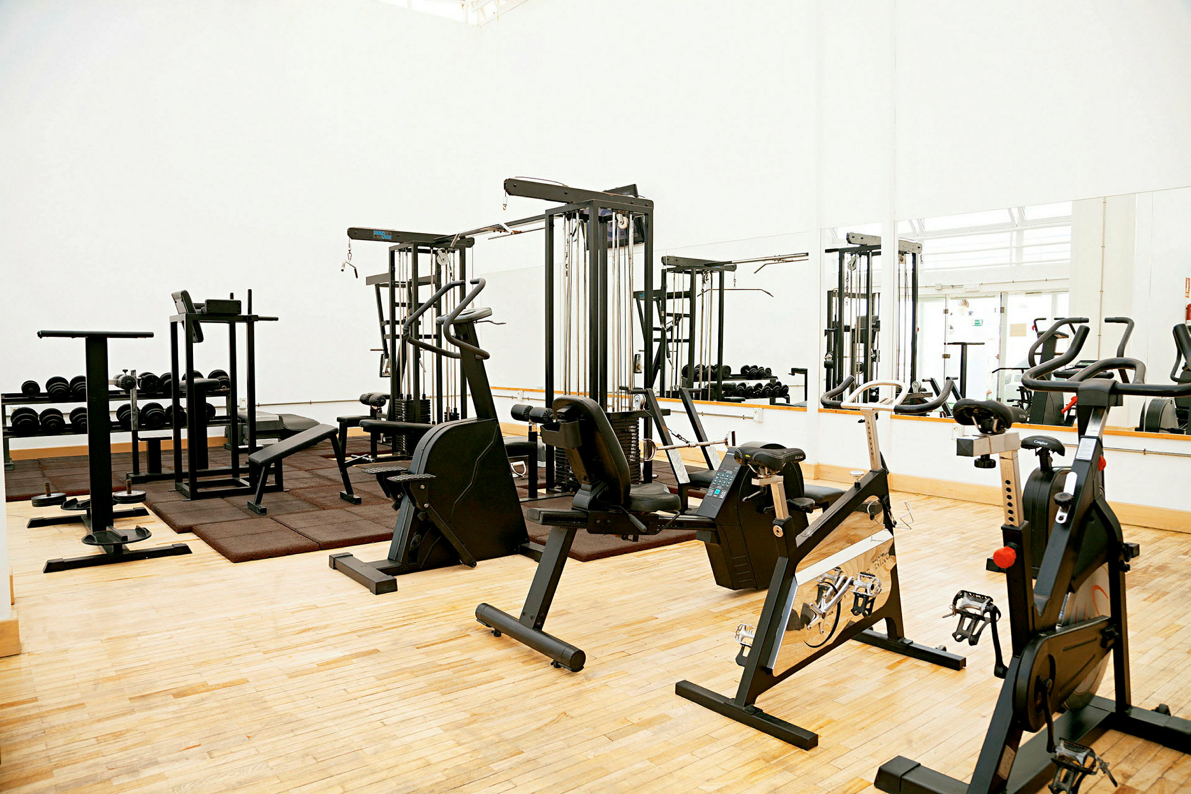 Fitnesscenter med træningsmaskiner og vægte. (AI-genereret tekst)