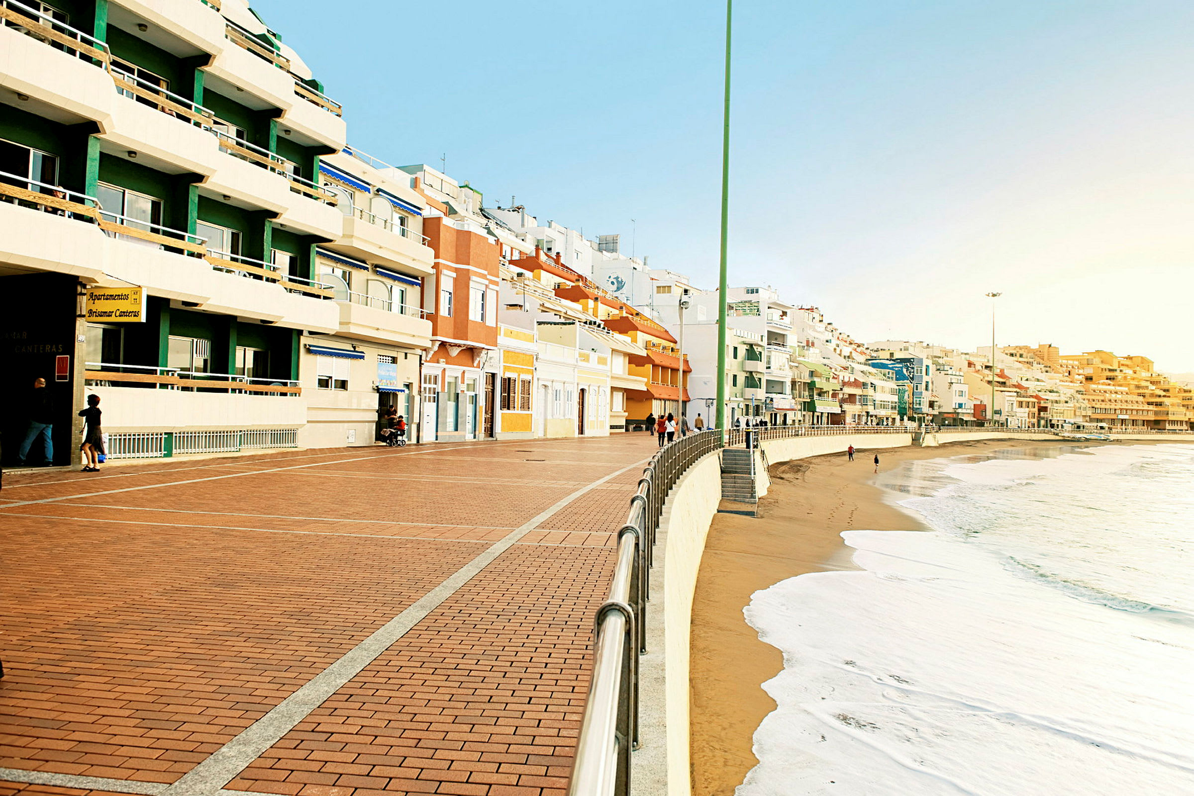 En strandpromenade med farverige bygninger langs kysten. (AI-genereret tekst)