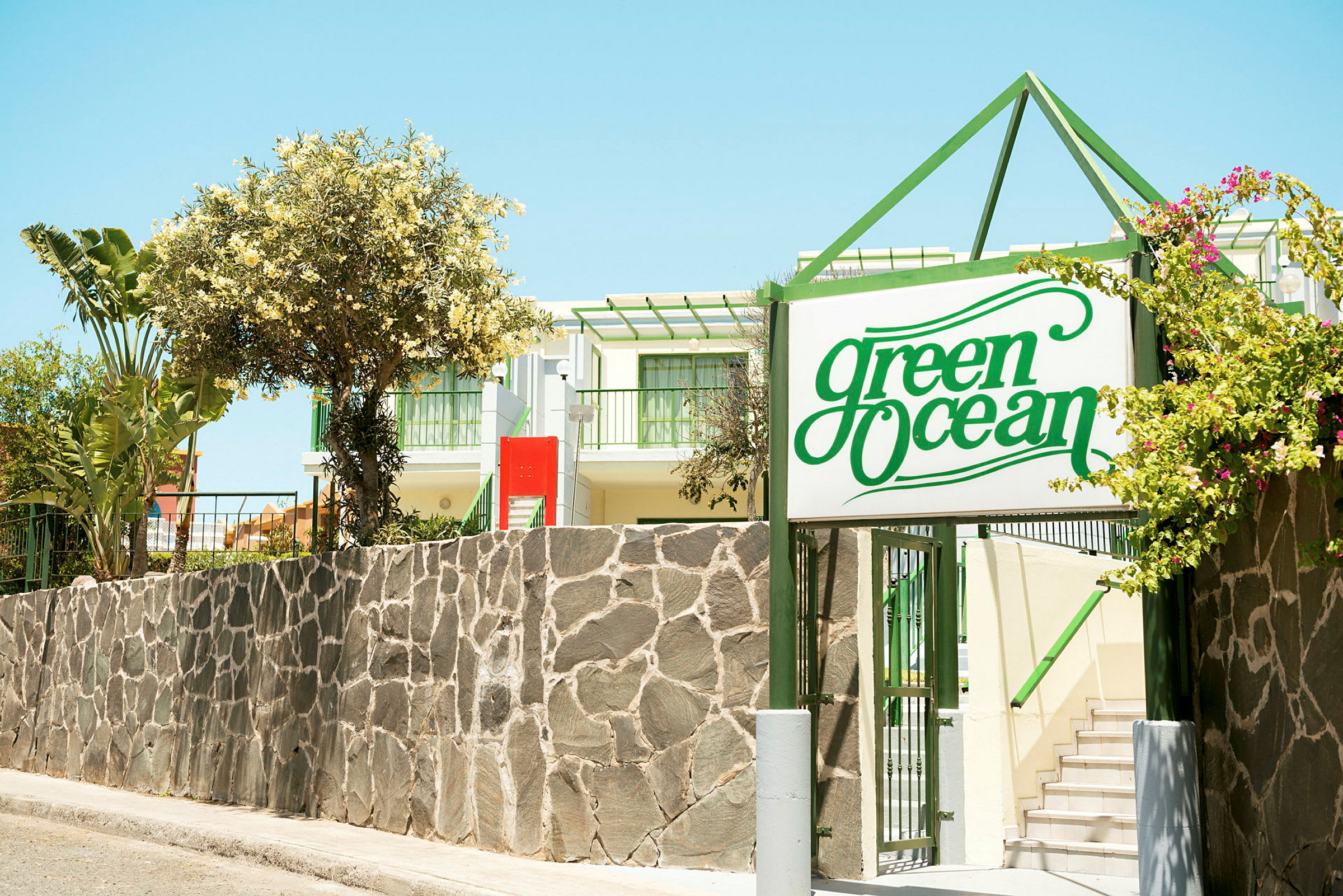 Hotelindgang med et skilt, der siger 'Green Ocean'. (AI-genereret tekst)