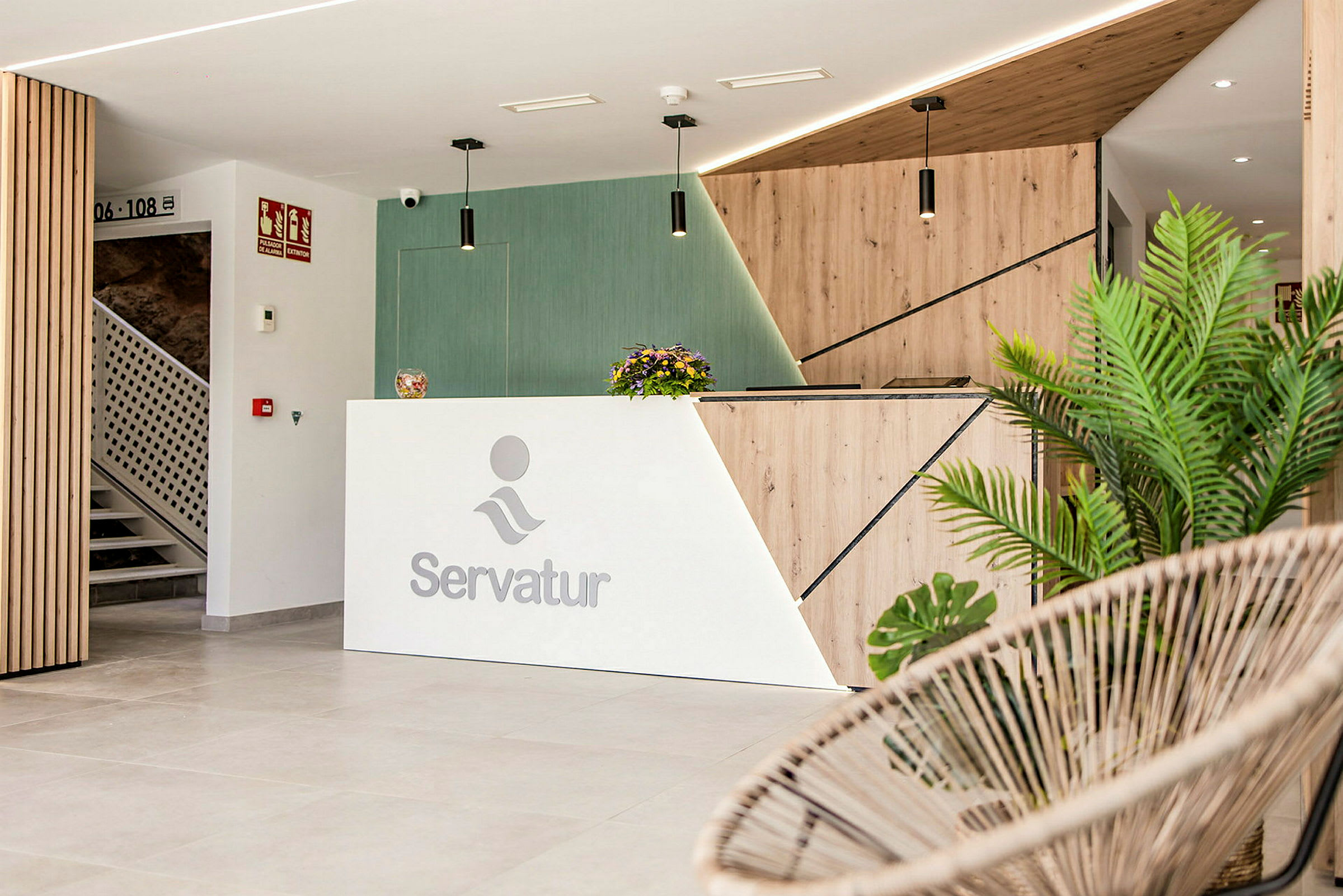 Reception med Servatur-logo, moderne design og dekorative planter. (AI-genereret tekst)