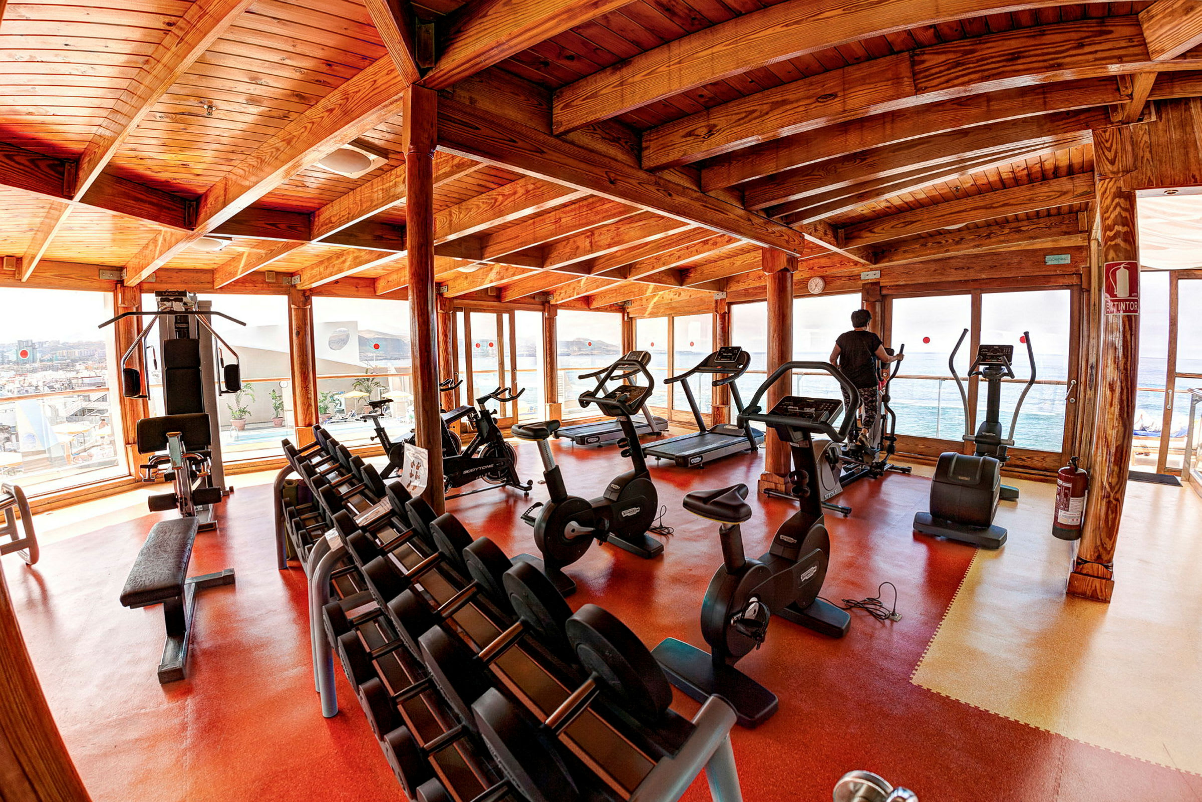 Fitnesscenter med træningsmaskiner og håndvægte. (AI-genereret tekst)