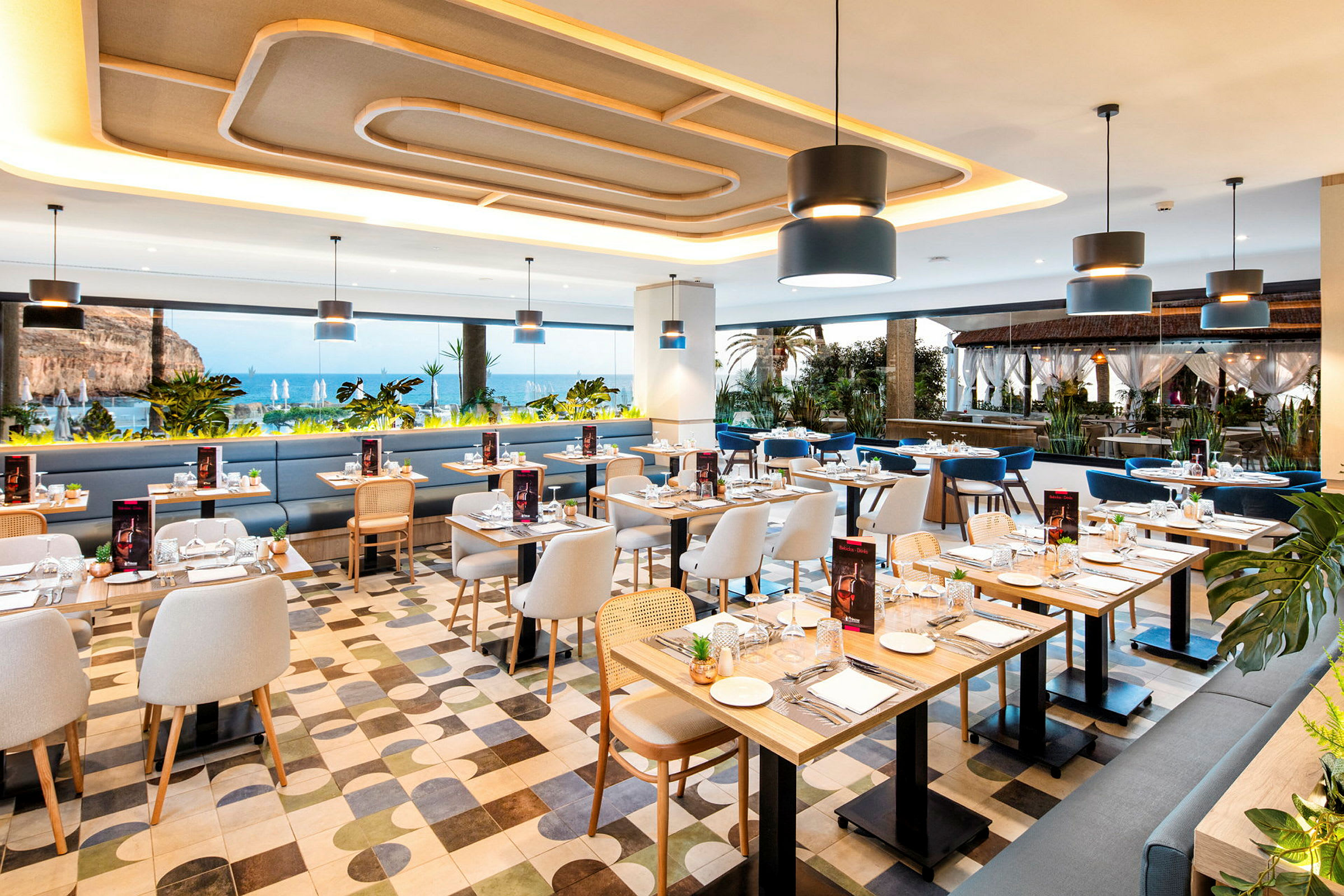 Interiør af en restaurant med havudsigt, moderne møbler og dækkede borde. (AI-genereret tekst)
