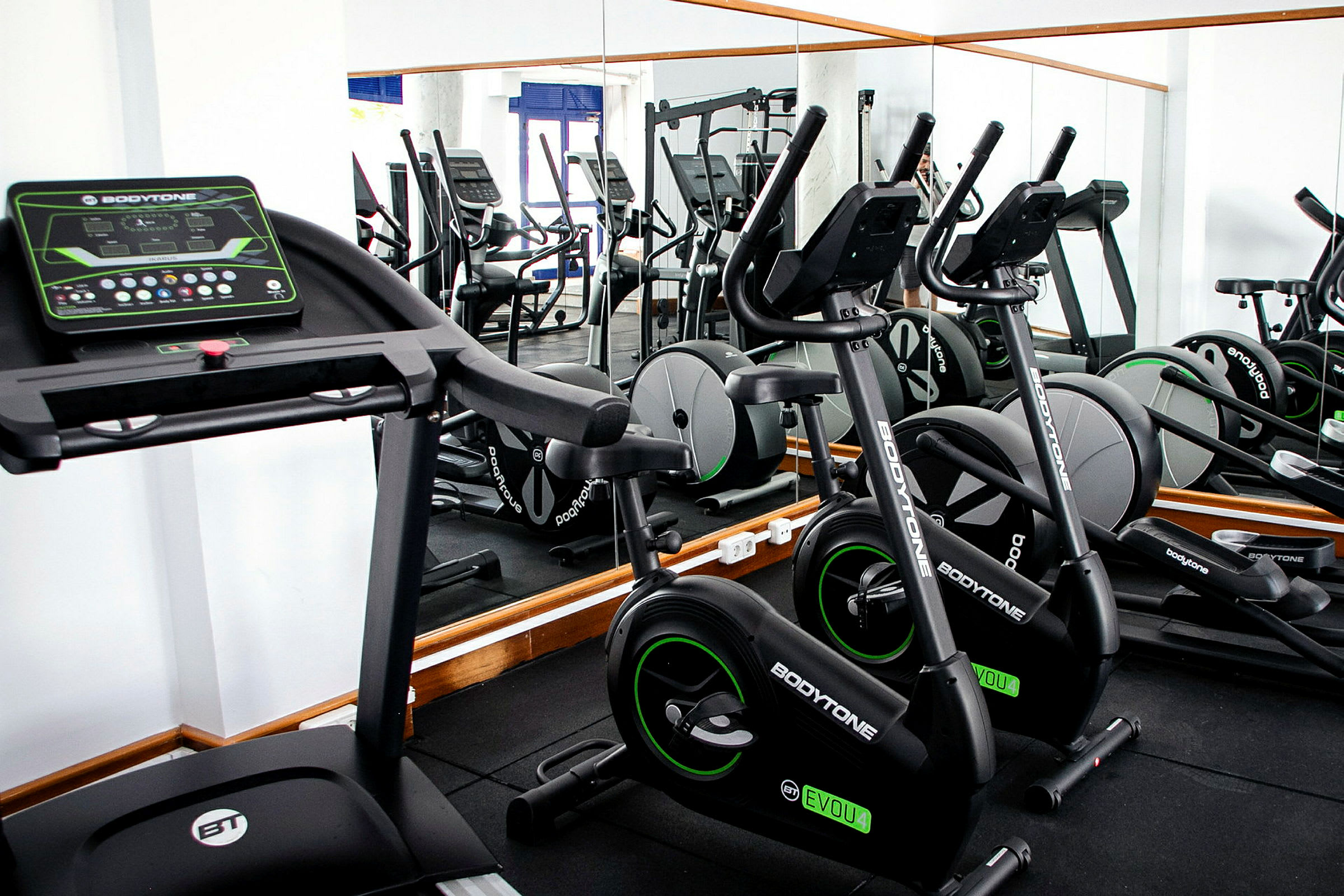 Træningscenter med motionsmaskiner, herunder løbebånd og motionscykel. (AI-genereret tekst)