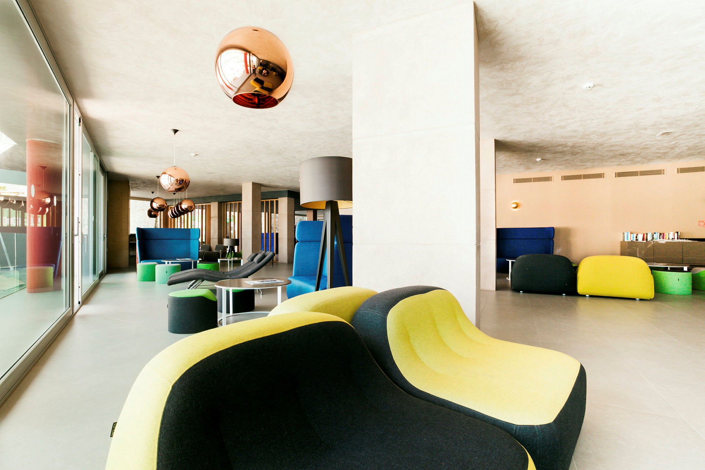 Moderne lounge med farverige møbler og kobberfarvede lamper. (AI-genereret tekst)