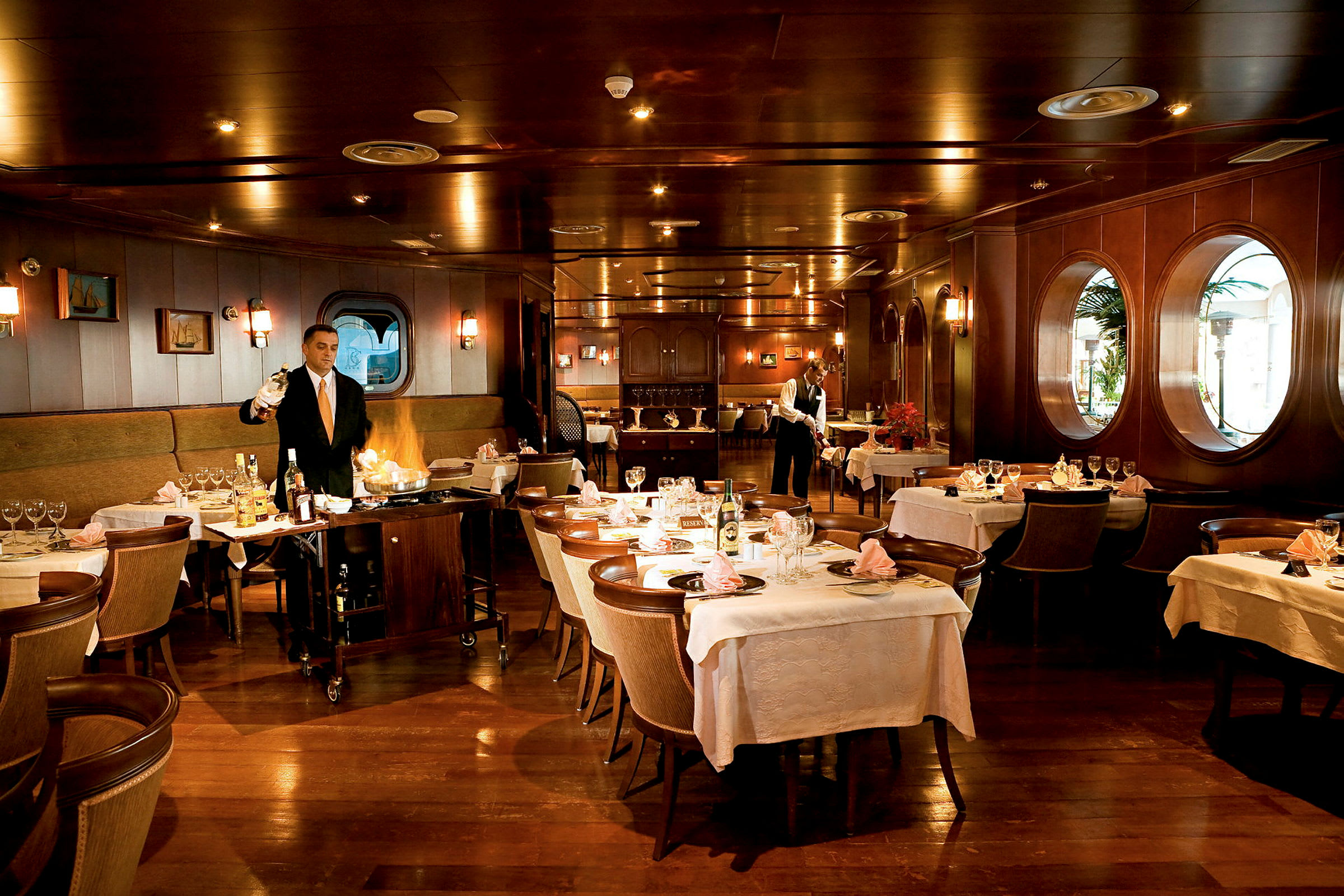 Interiør af en elegant restaurant med dækkede borde og træpaneler. (AI-genereret tekst)