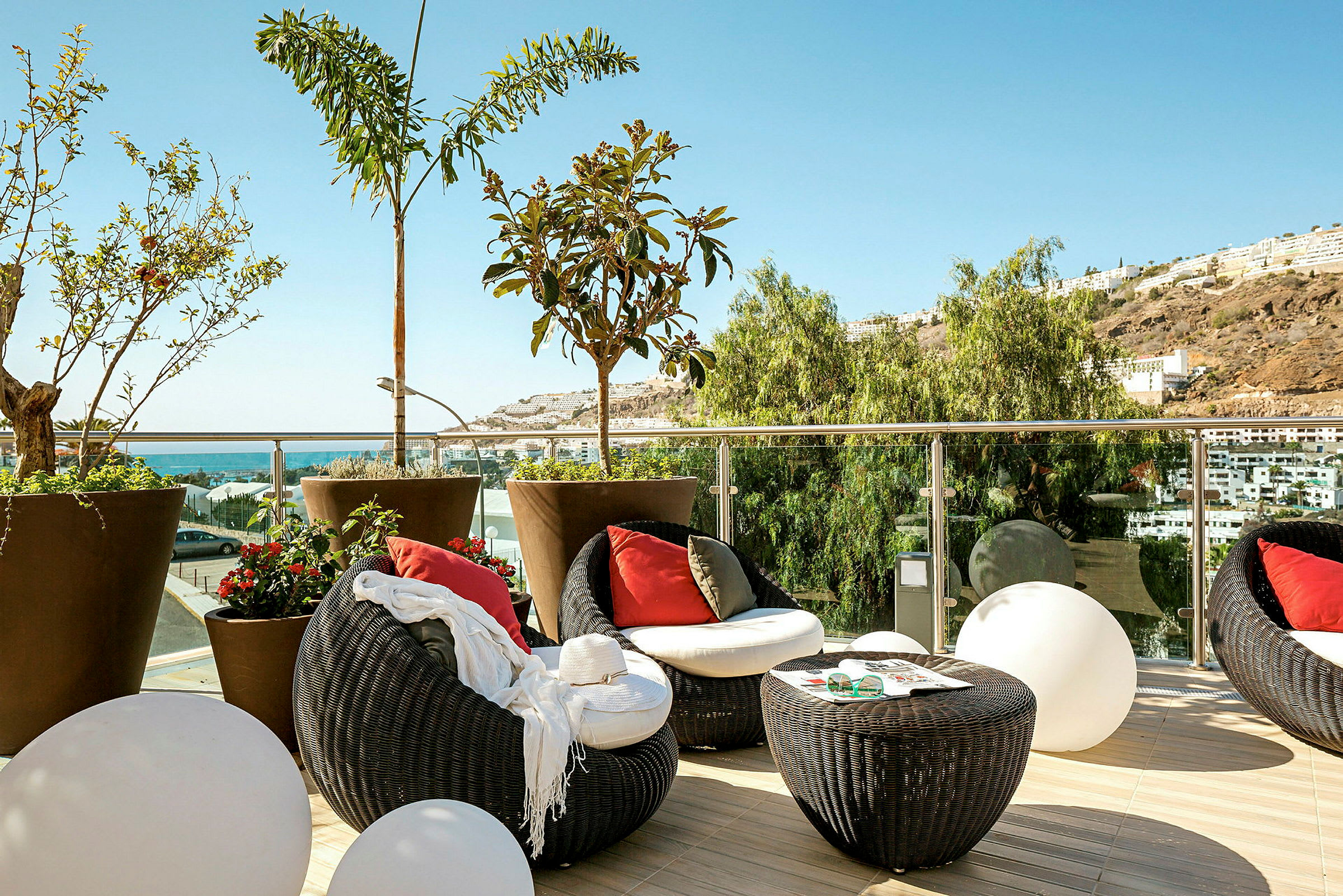 Terrasse med siddeområde og udsigt over havet og omgivelserne. (AI-genereret tekst)