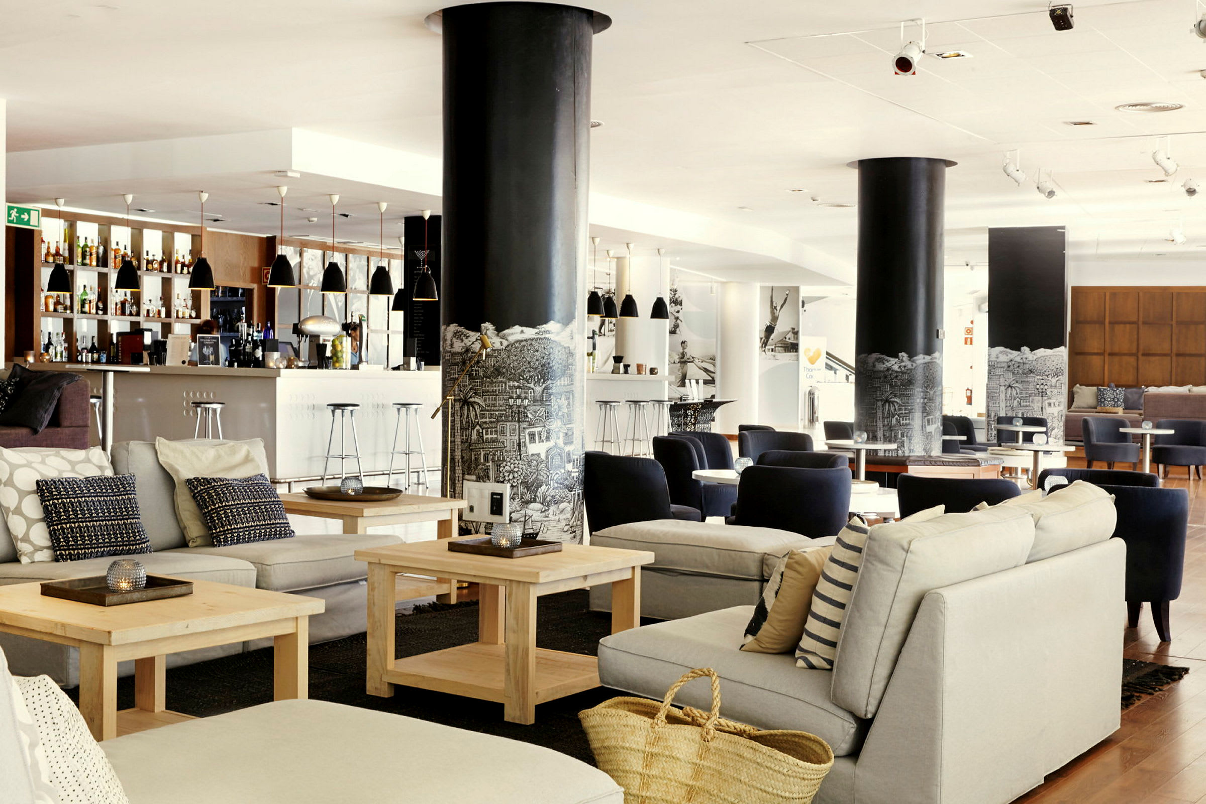 Lyst og moderne loungeområde med siddegrupper og en bar. (AI-genereret tekst)