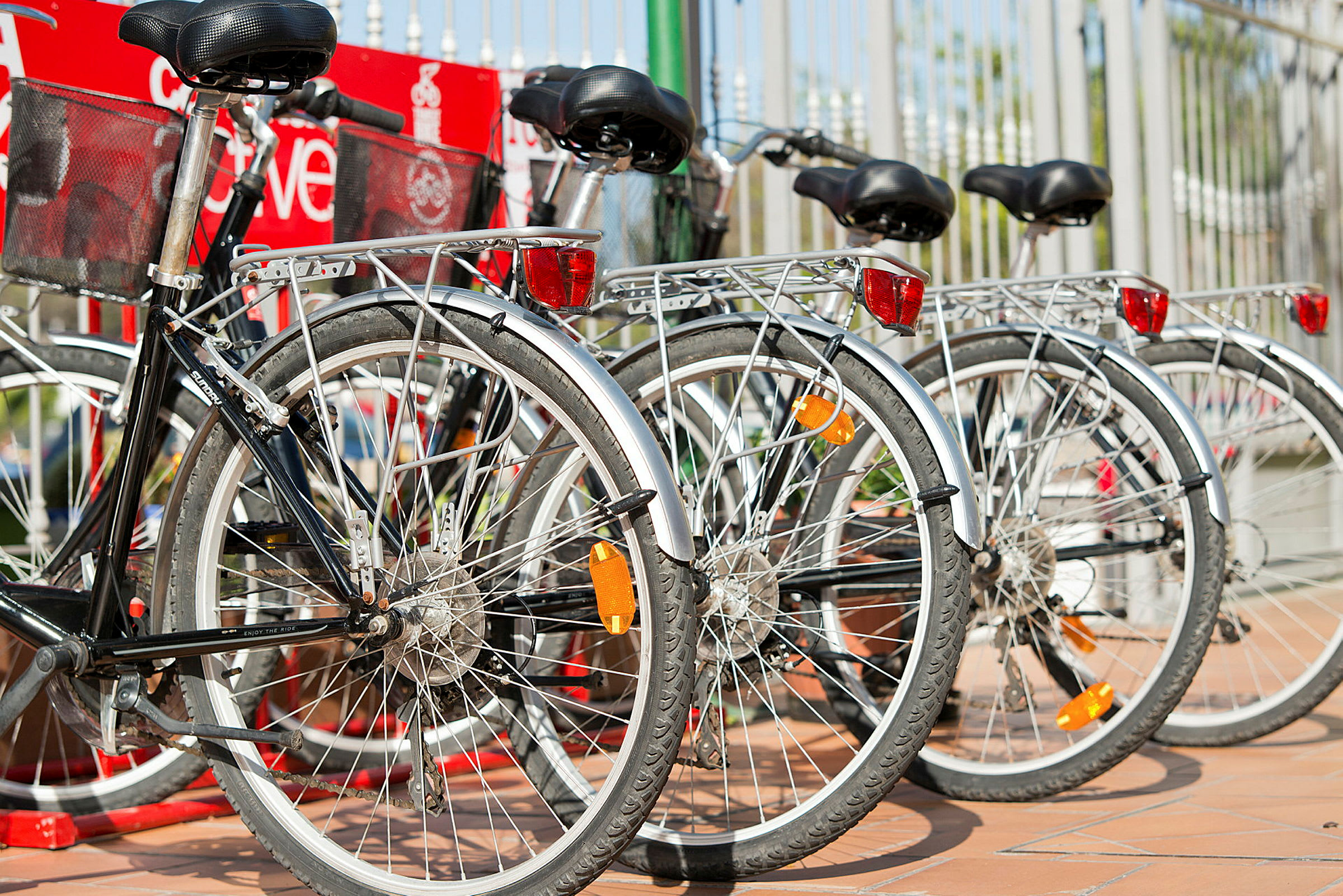 En række parkerede cykler ved et rækværk. (AI-genereret tekst)