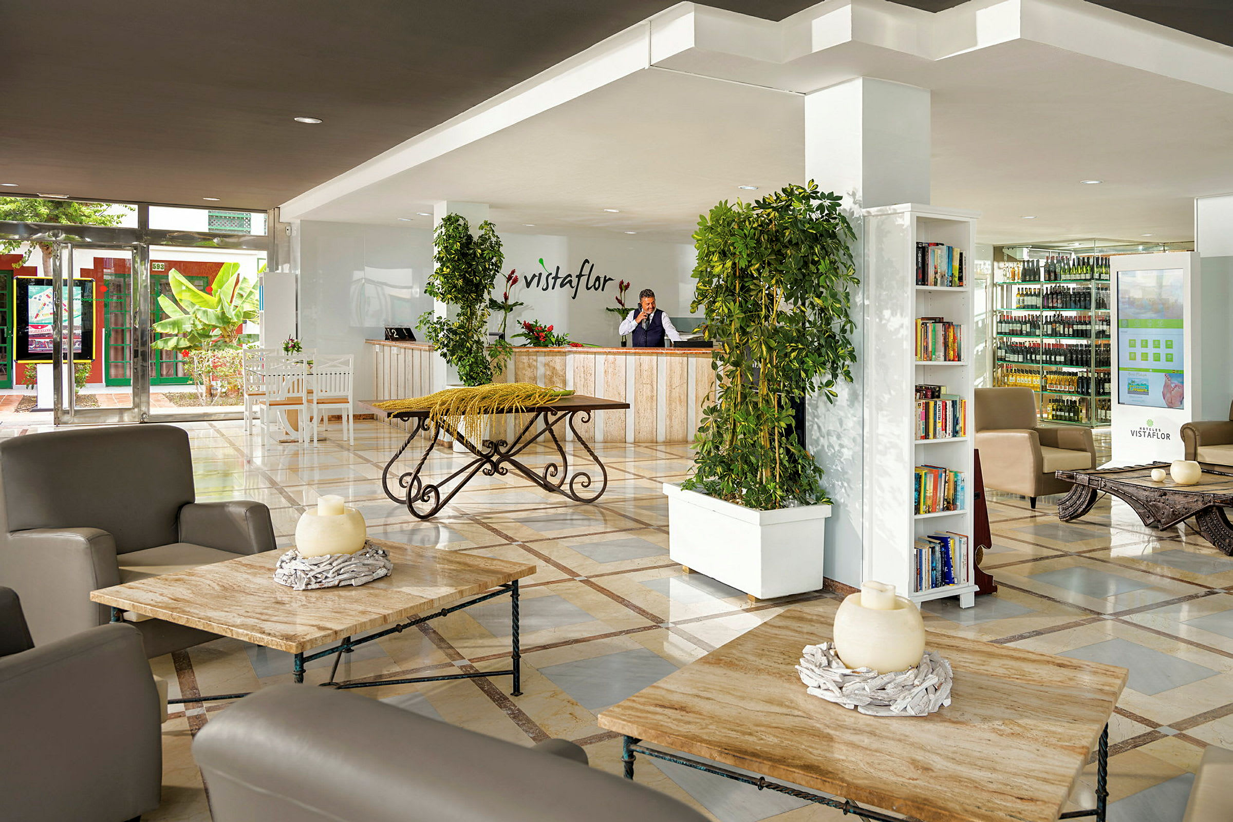 Reception og lobby med siddeområder, planter og bogreol. (AI-genereret tekst)