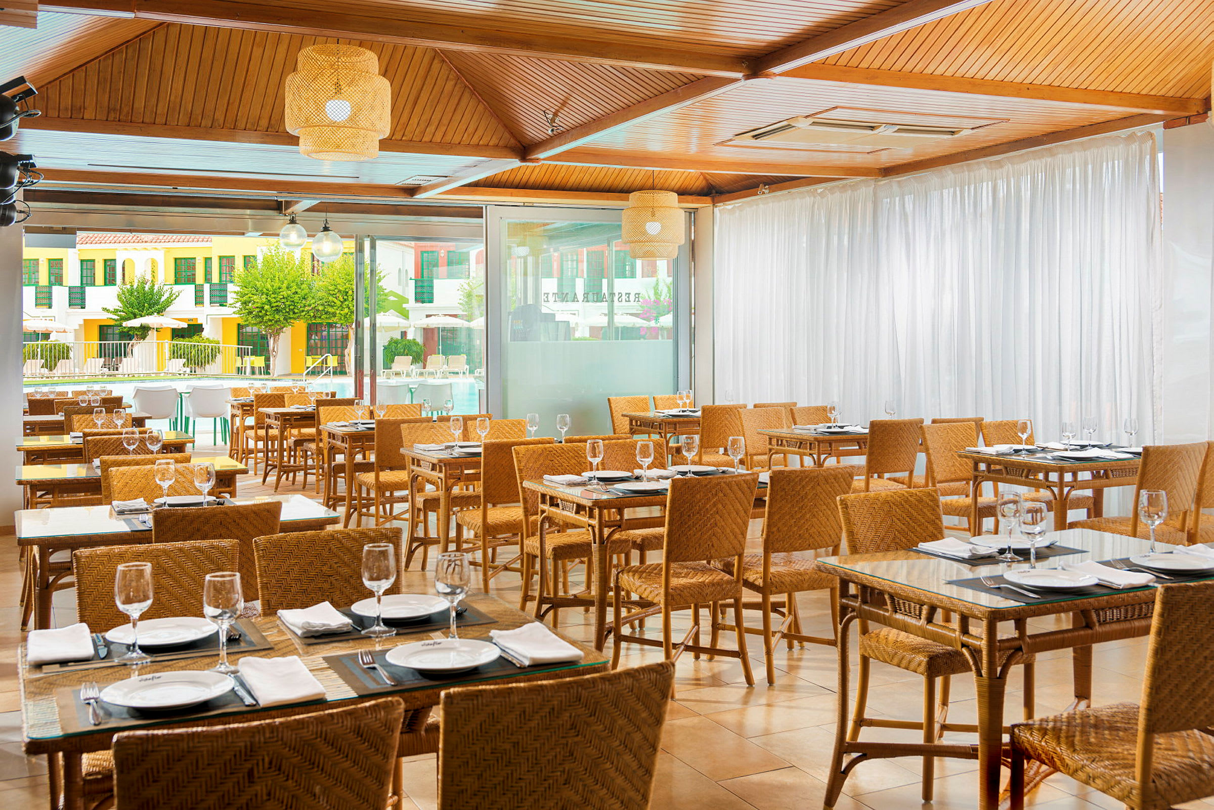 Indendørs restaurant med dækkede borde og kurvestole. (AI-genereret tekst)