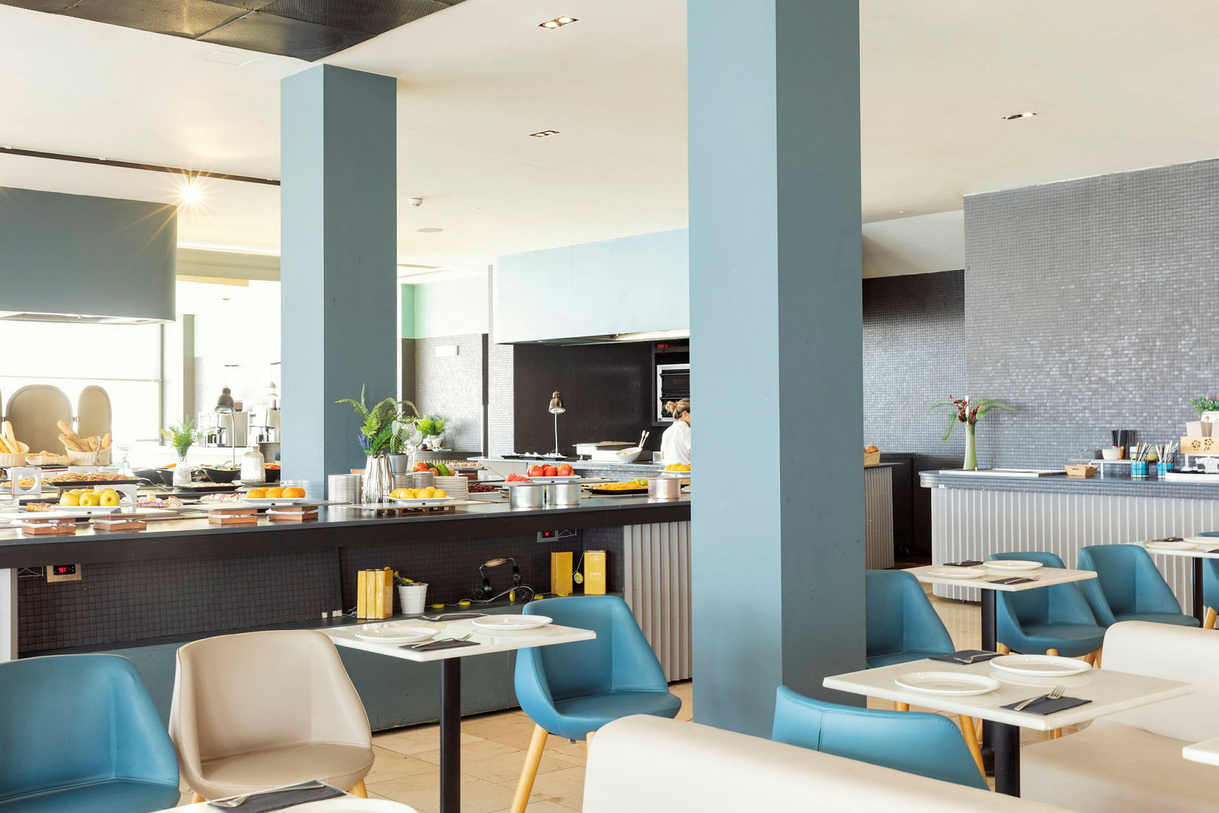 Interiør af en restaurant med serveringsborde og dækkede siddepladser. (AI-genereret tekst)