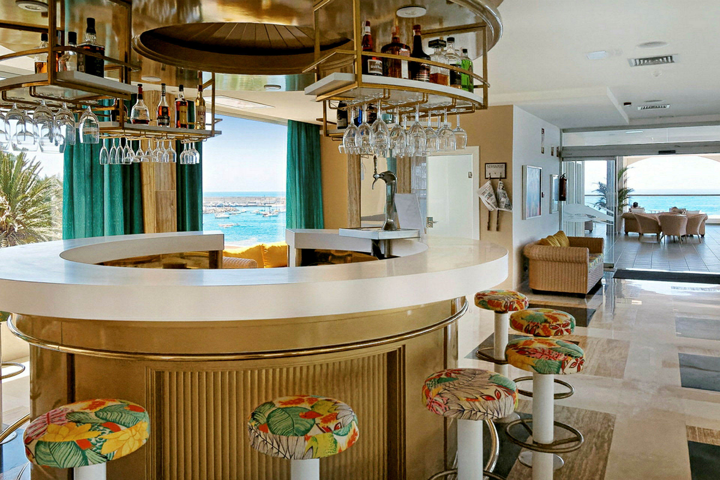 En rund bar med farverige stole og udsigt over havet. (AI-genereret tekst)
