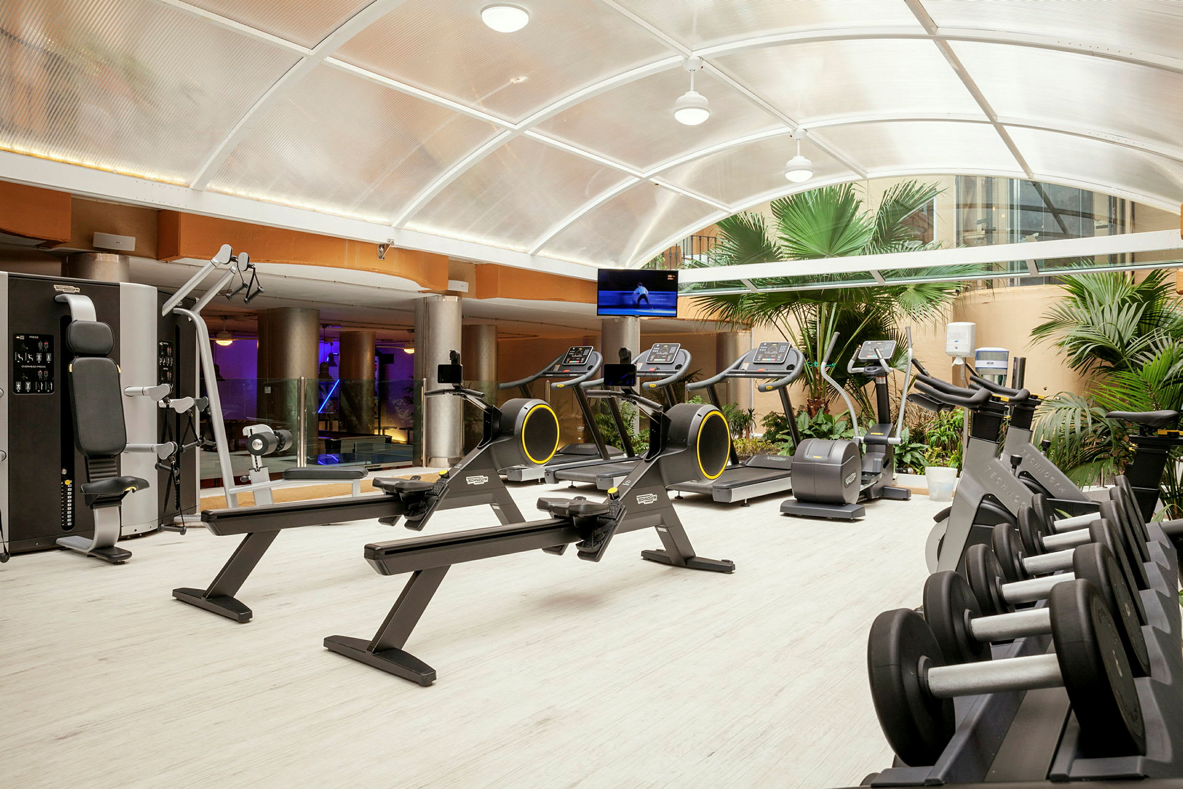 Fitnesscenter med forskellige træningsmaskiner og vægte. (AI-genereret tekst)