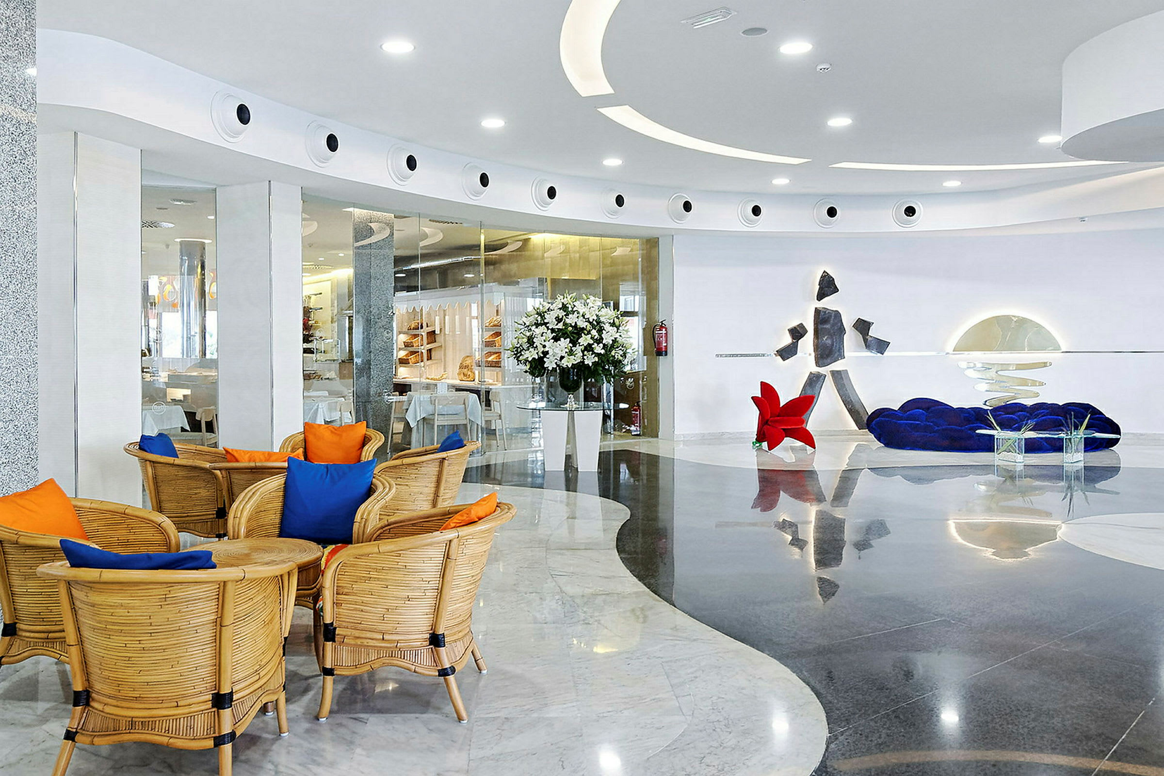 Moderne indrettet hotellobby med siddeområde, dekorative elementer og blomster. (AI-genereret tekst)