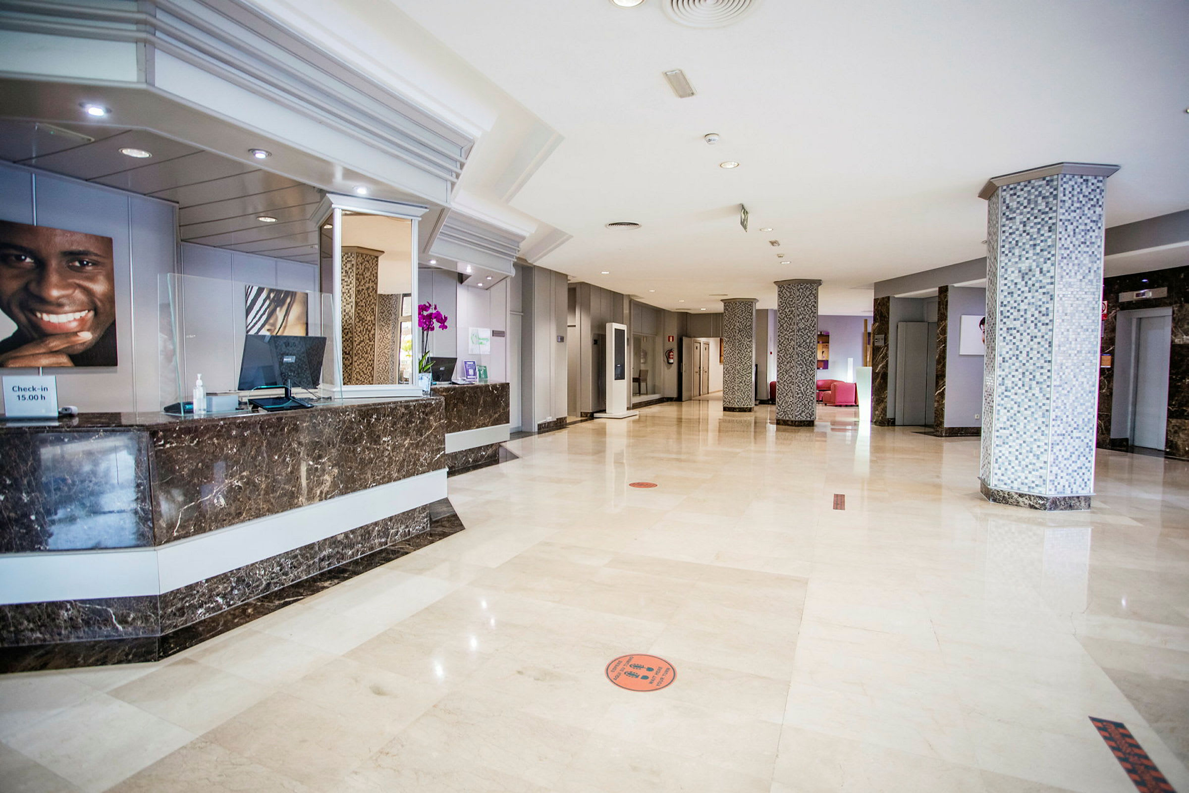 Hotellobby med marmorgulv og reception. (AI-genereret tekst)