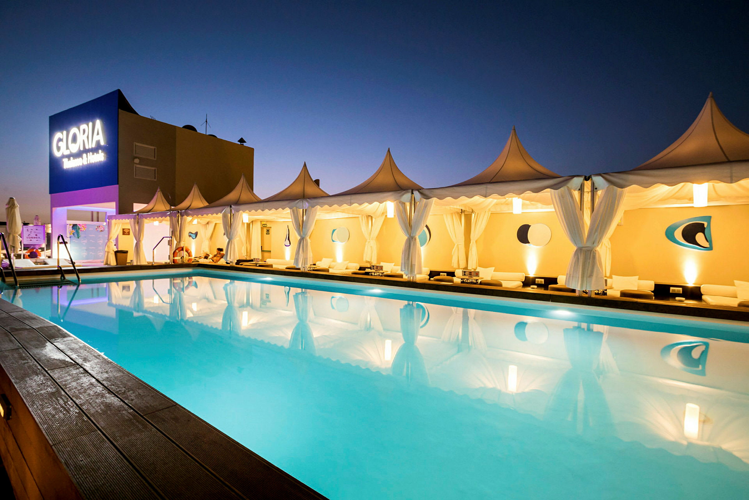 En pool omgivet af telte med belysning ved Gloria Palace. (AI-genereret tekst)