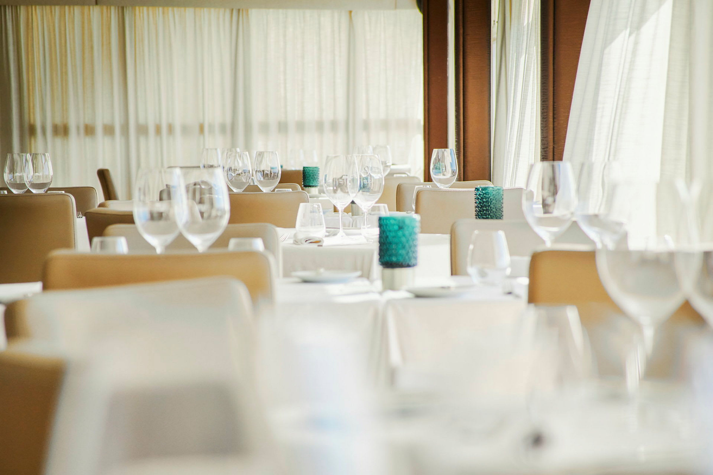 Et elegant restaurantområde med dækkede borde, siddepladser og dekorative glas. (AI-genereret tekst)