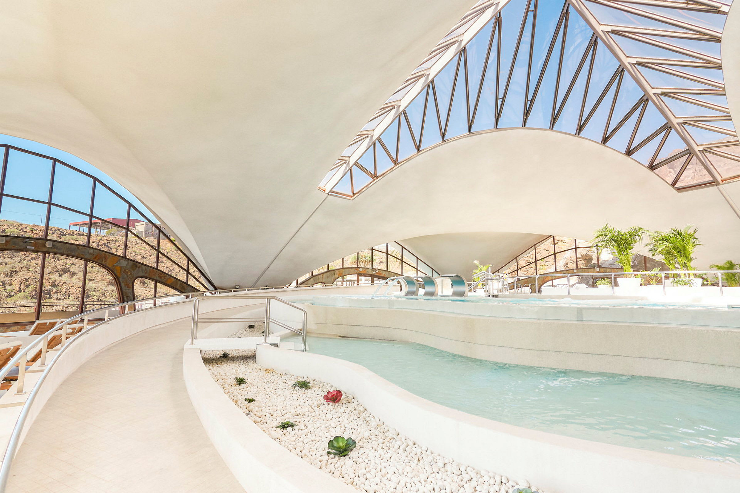 Indendørs swimmingpool med moderne arkitektur og store vinduer. (AI-genereret tekst)