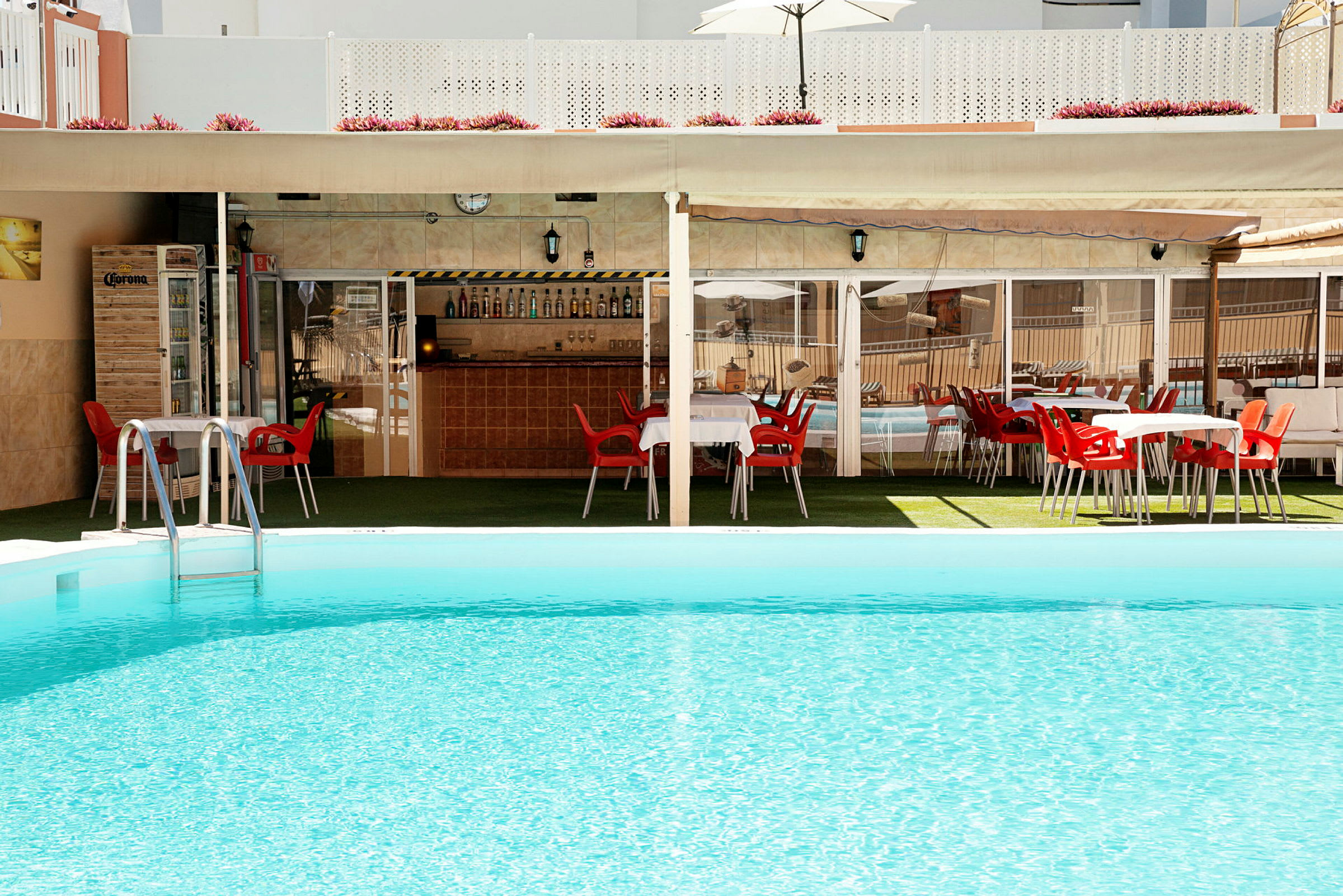 Pool med tilstødende siddepladser og bar. (AI-genereret tekst)