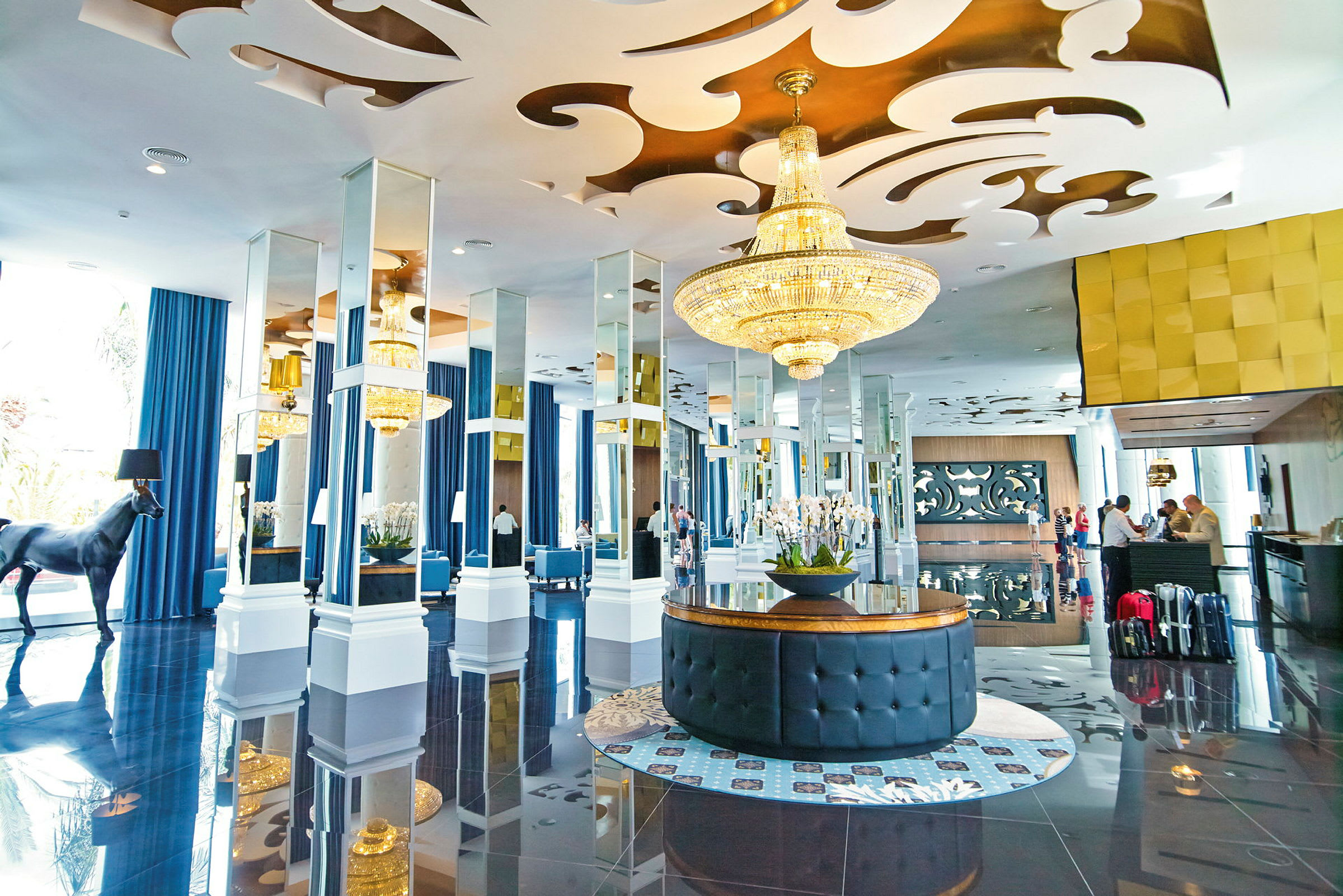 Hotellobby med elegant indretning, lysekroner og spejle. (AI-genereret tekst)